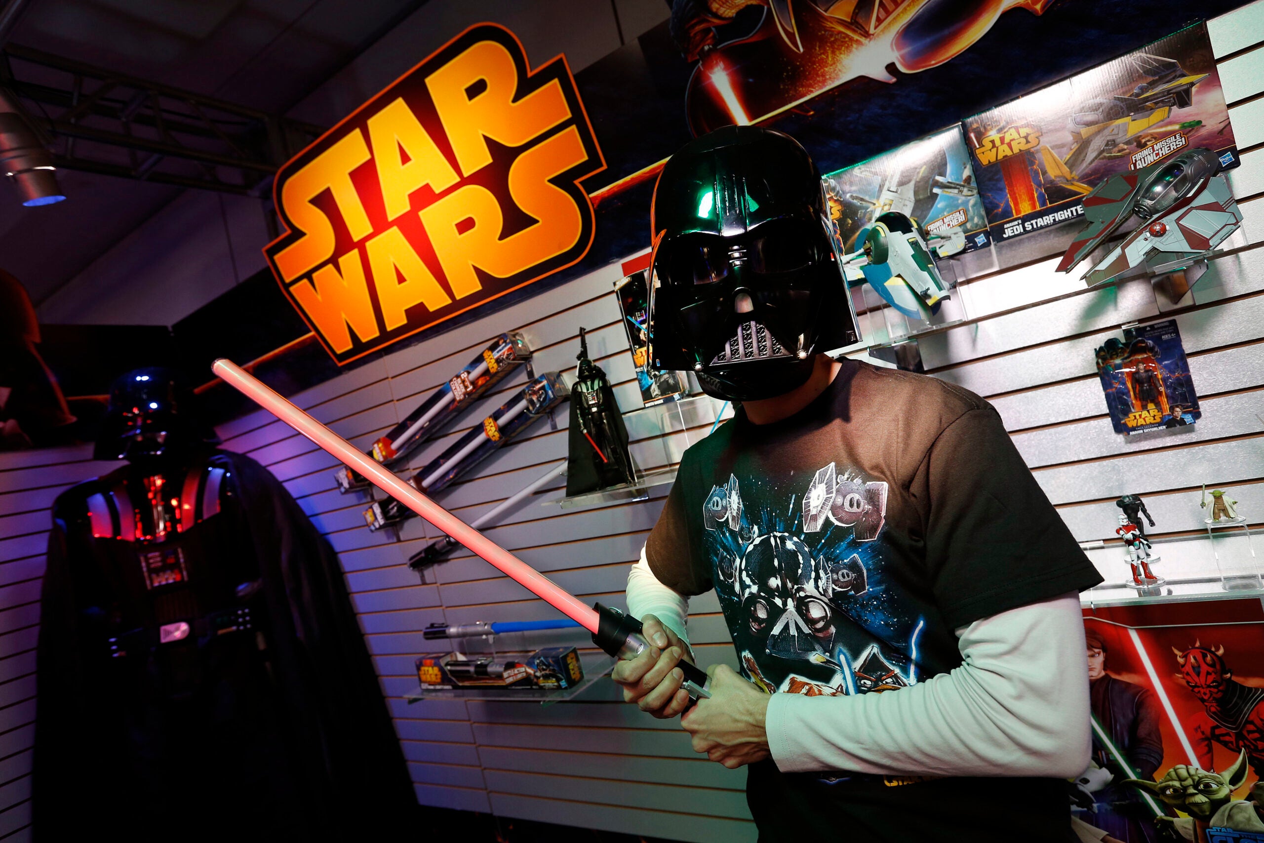 Jeff wolf holds a lightsaber