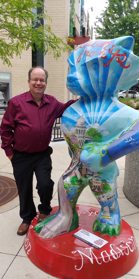 Pete Loerke poses on the Capitol Square in Madison next to a Bucky Badger statue