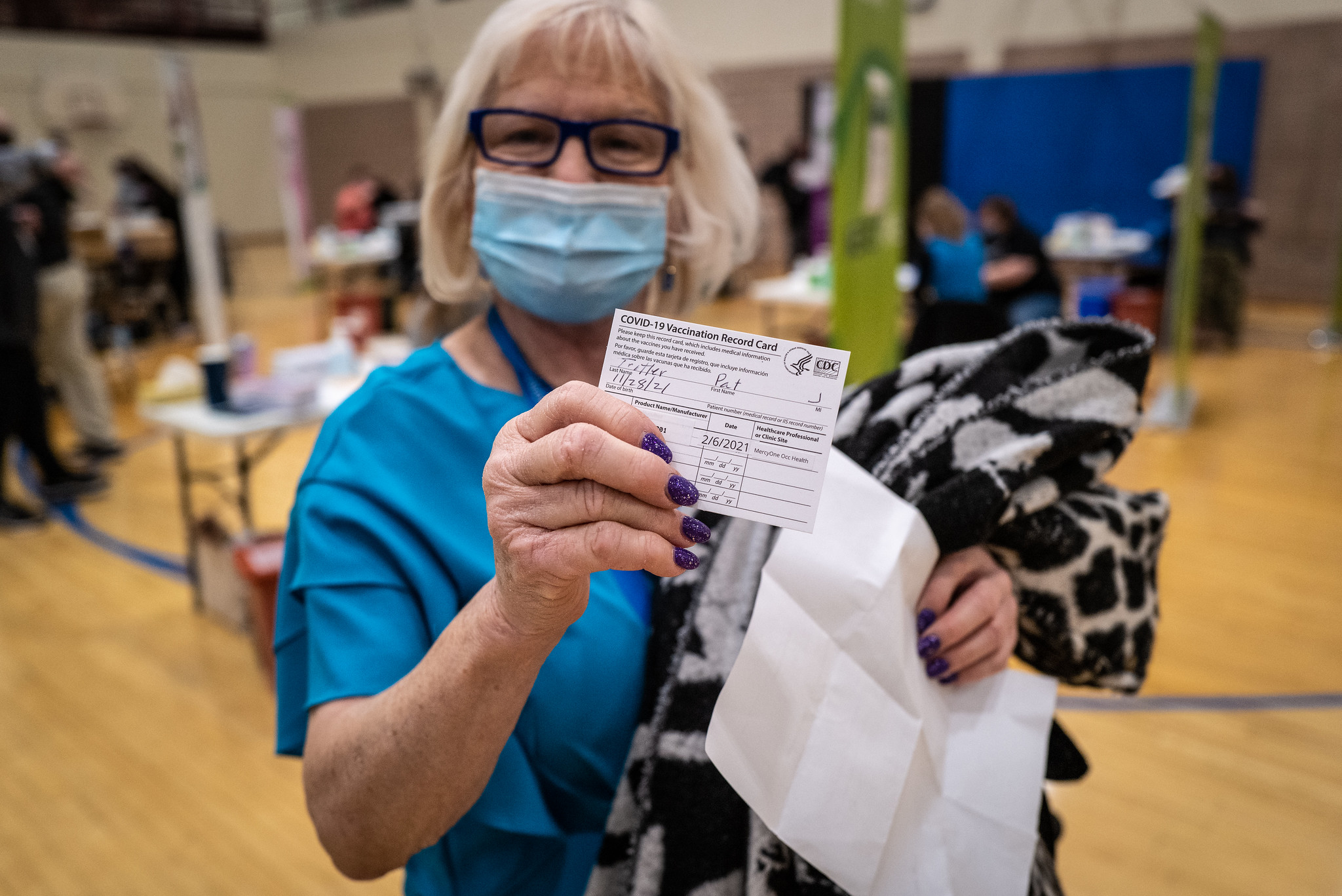 A person holds up their Covid-19 vaccine card
