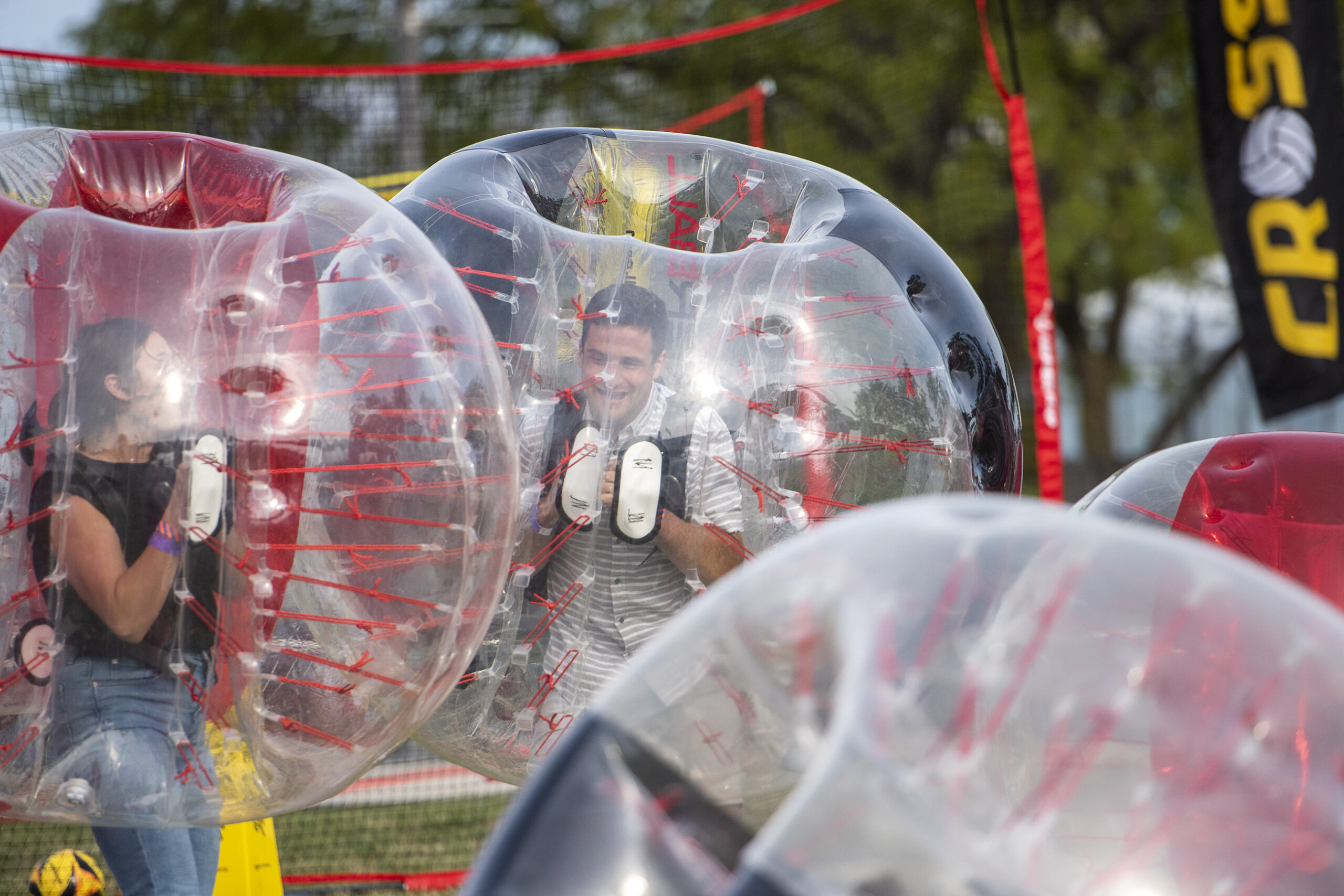 Attendees play a game inside of large inflatable balls.