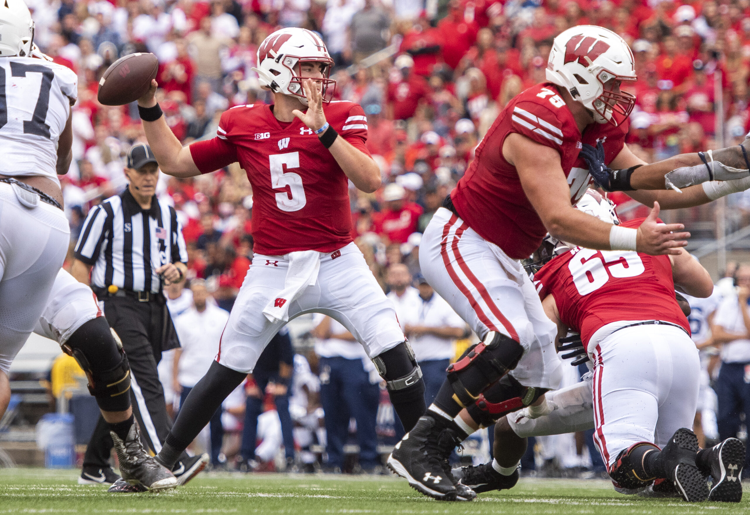 The Wisconsin quarterback reaches back holding the ball before passing.