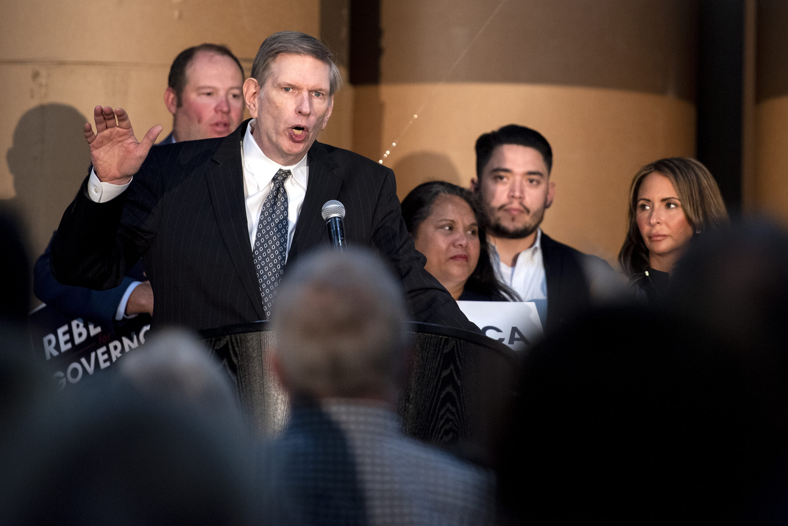 Eric Severson gestures as he speaks on stage.