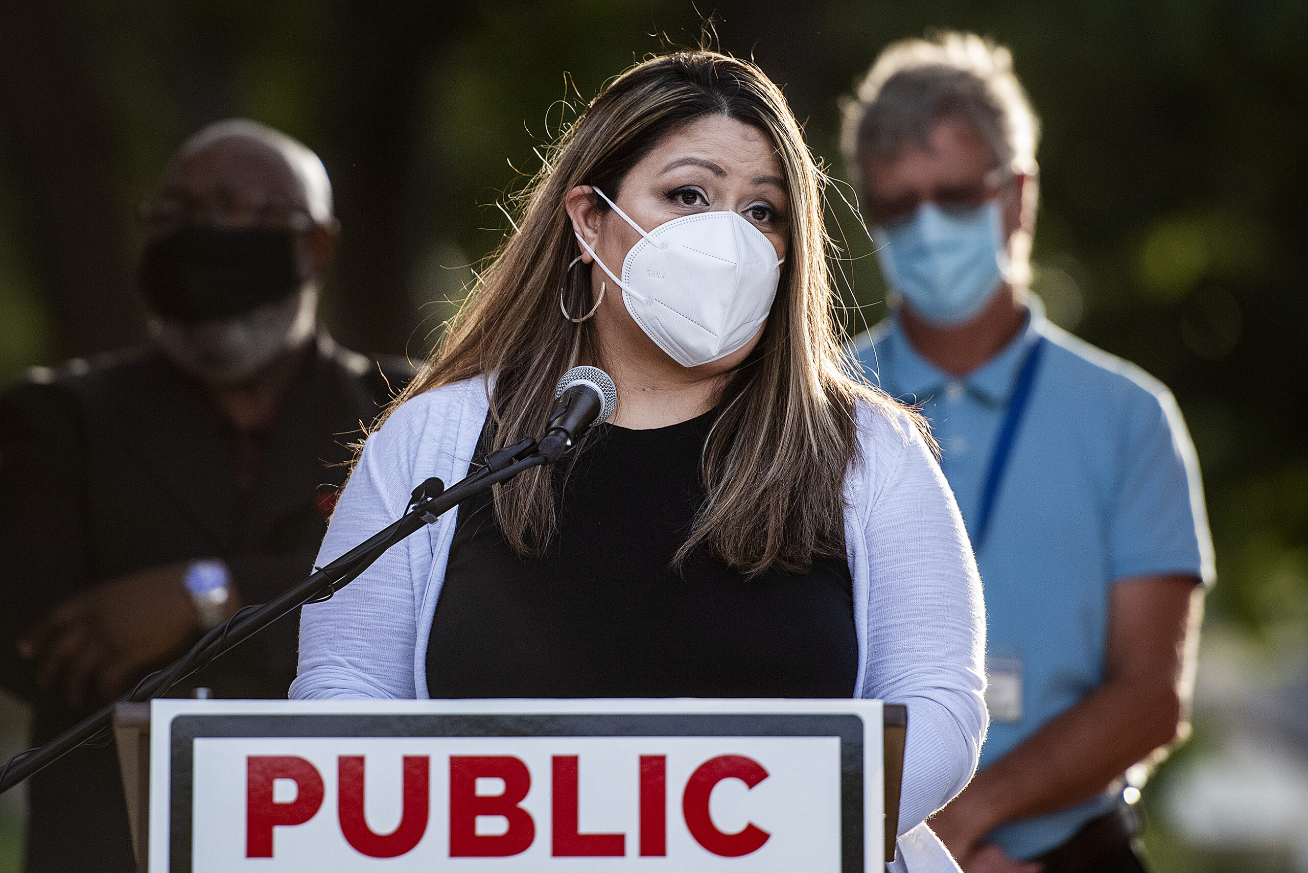 Lisa Guerrero wears a face mask as she speaks at a podium.