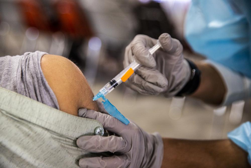 Medical worker vaccinates Afghan evacuee
