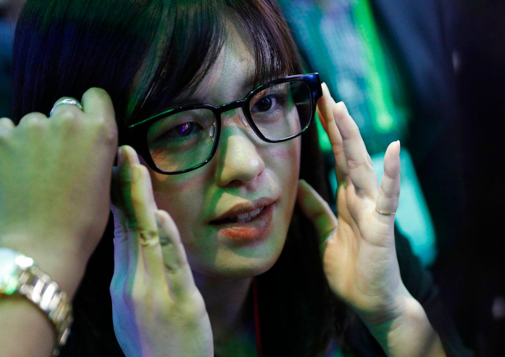 A woman tries on a pair of normal-looking eye glasses with special technology.