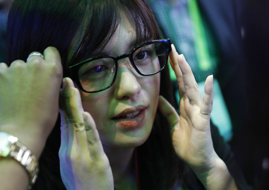 A woman tries on a pair of normal-looking eye glasses with special technology.