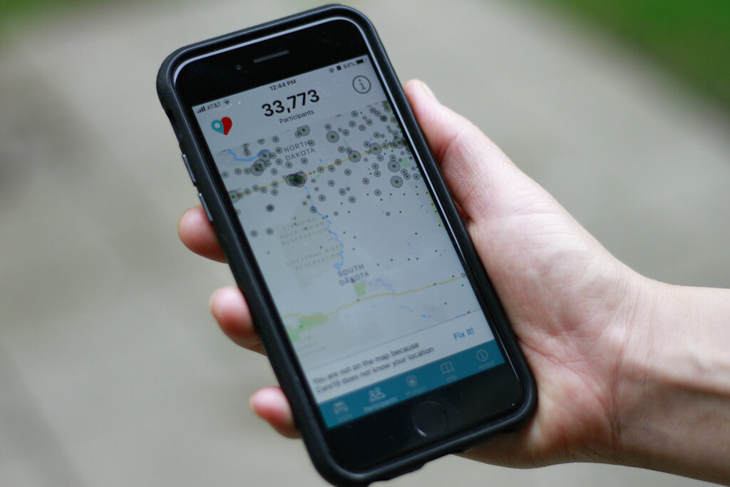 A close-up shot of a hand holding a phone with an app open that displays a map and points.