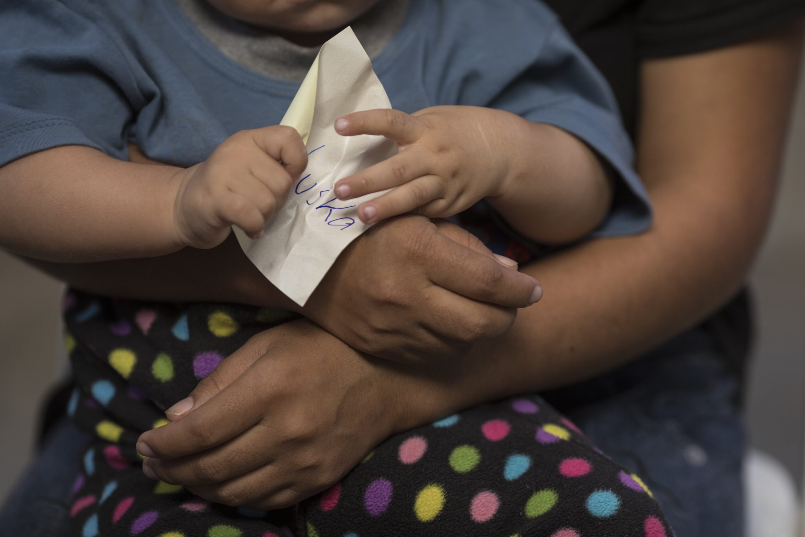 A woman holds her son during group therapy at one of two city shelters opened during the COVID-19 lockdown for women who suffer from domestic violence in Lima, Peru, Friday, April 24, 2020.