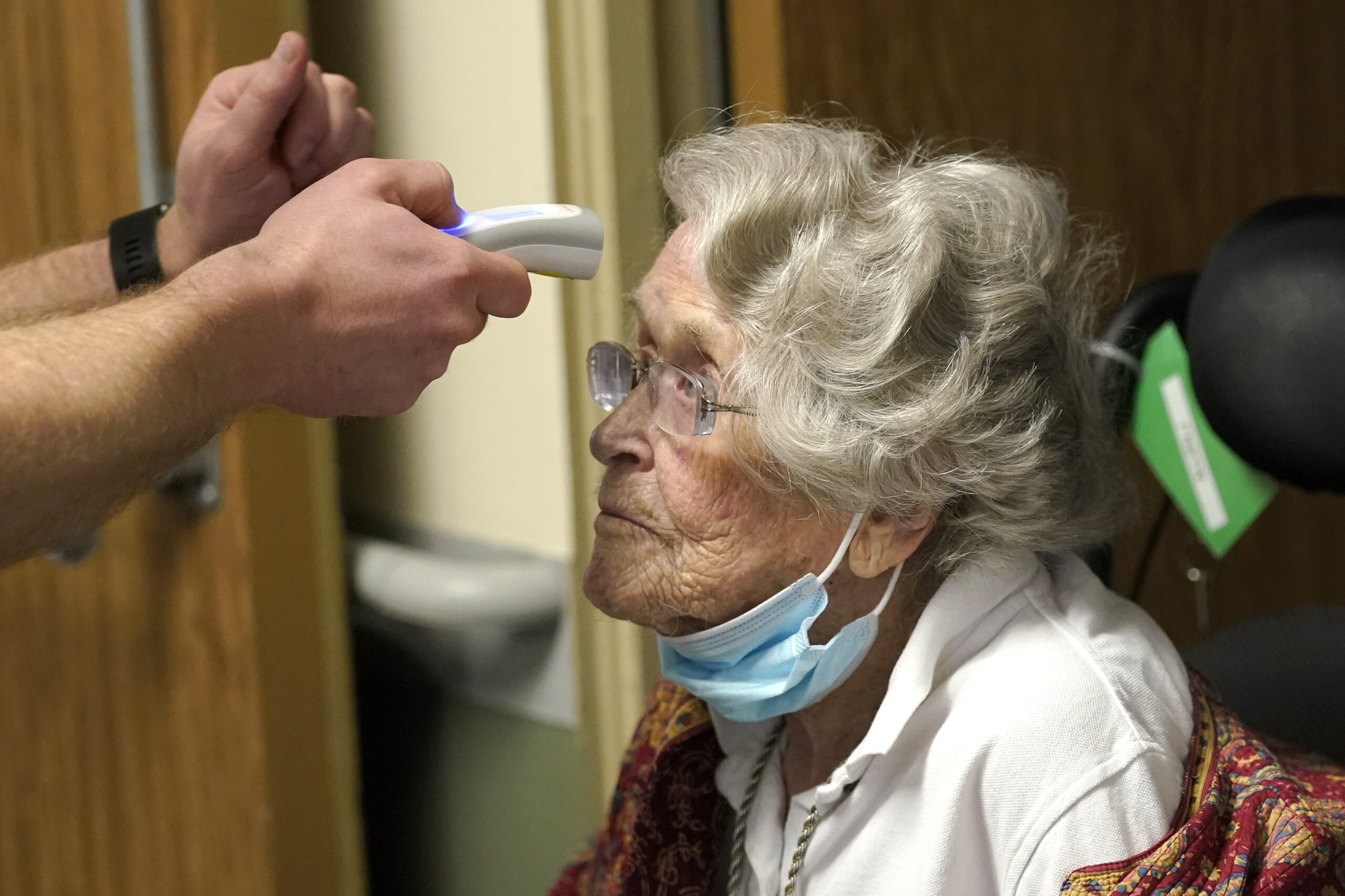 Jean Allen, 96, has her temperature taken before she received the first shot of the Pfizer vaccination for COVID-19