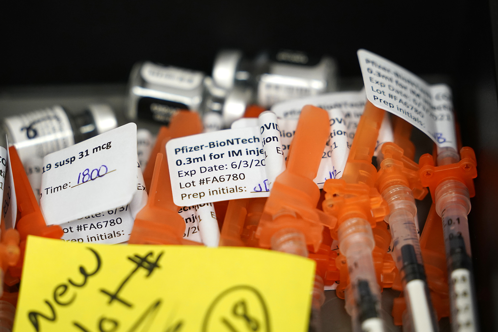 Syringes filled with Pfizer COVID-19 vaccines sit at the ready at a vaccination clinic.