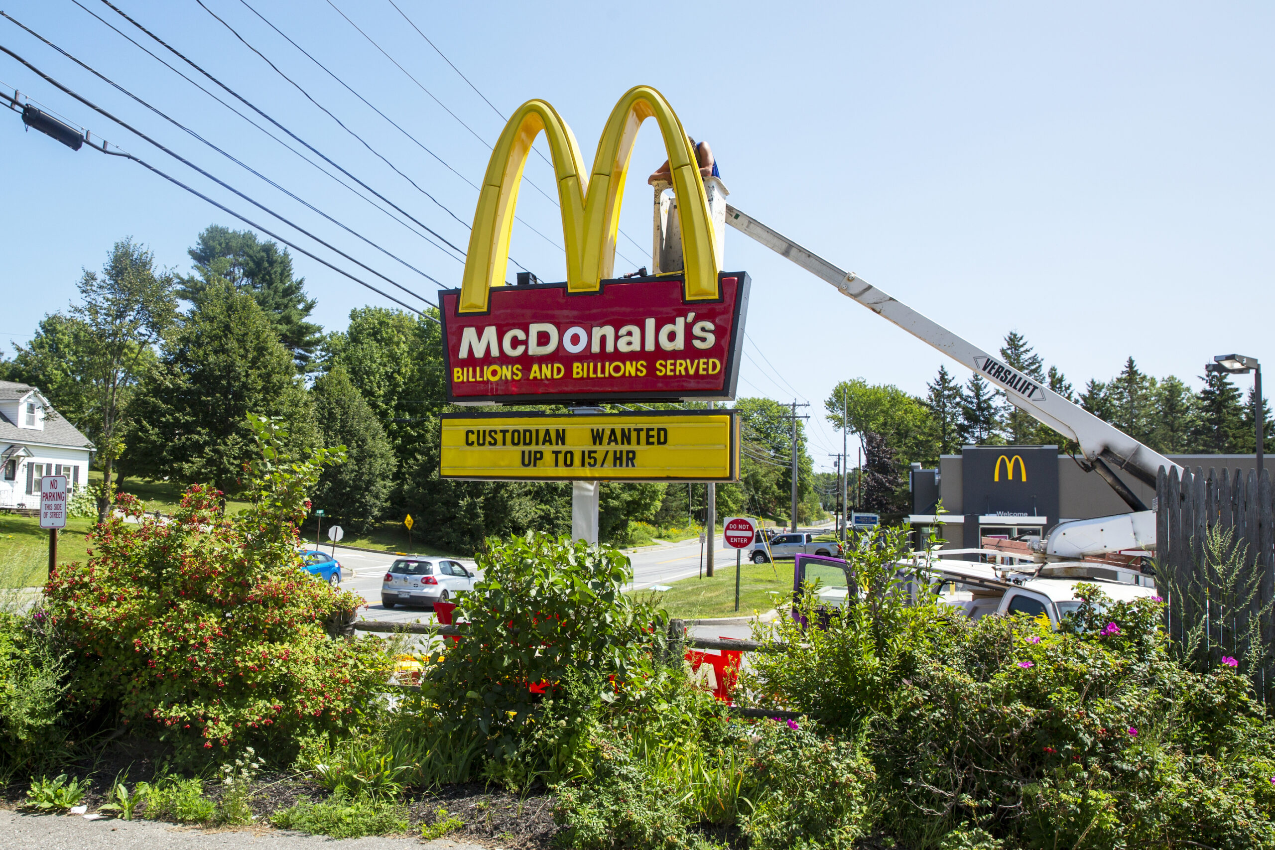 A man adjusting a McDonald's sign