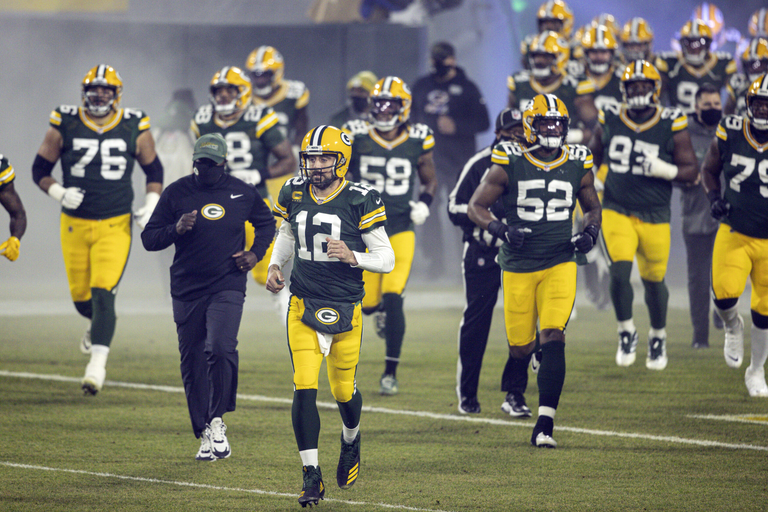 Green Bay Packers' Aaron Rodgers runs out with teammates during an NFL football game against the Carolina Panthers