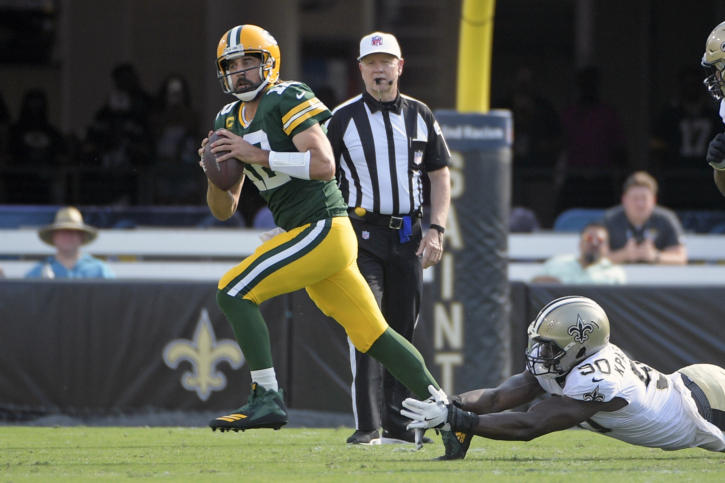 Green Bay Packers quarterback Aaron Rodgers scrambles as he is pressured by New Orleans Saints linebacker Tanoh Kpassagnon