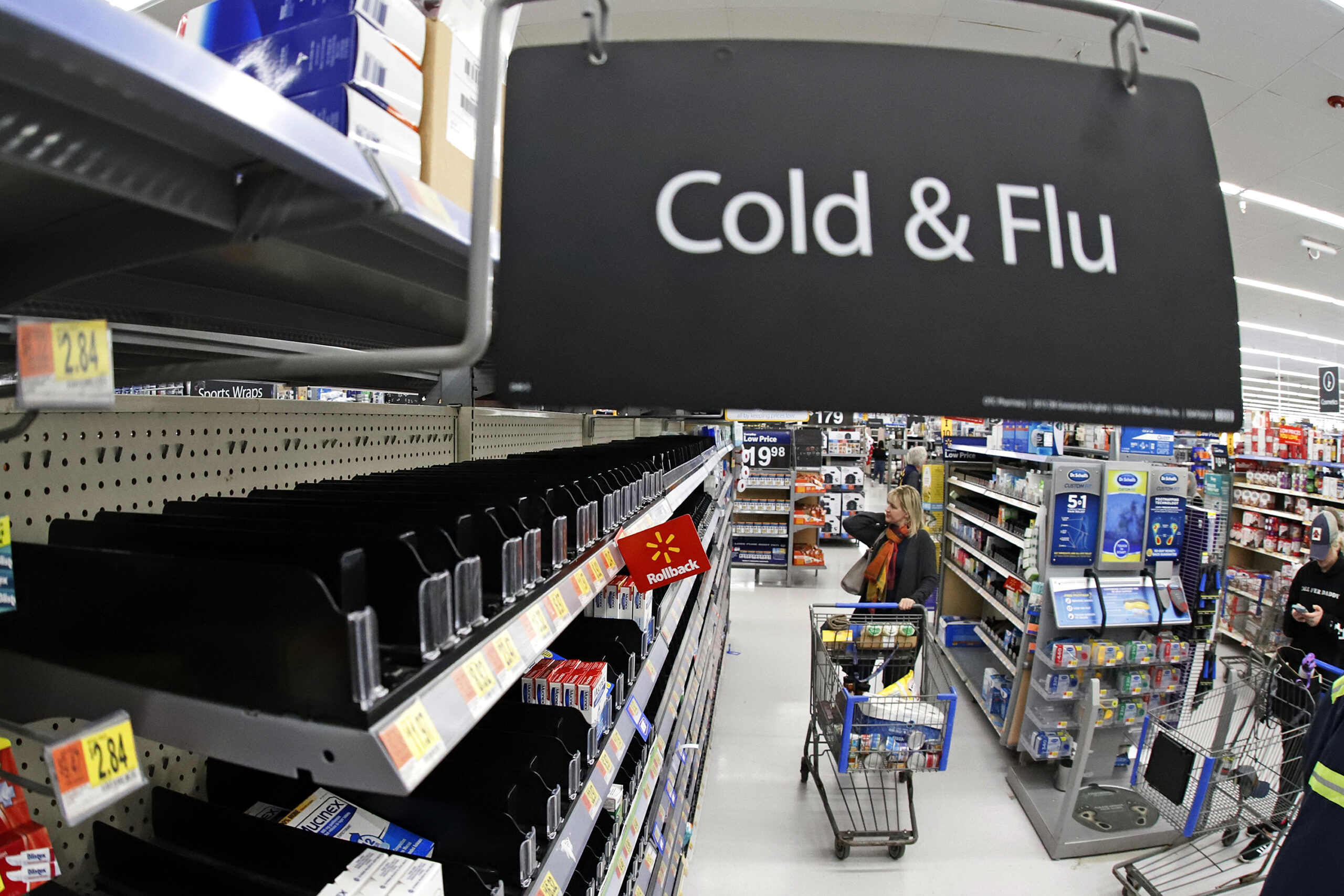 A shopper in the cold and flu aisle of a Walmart
