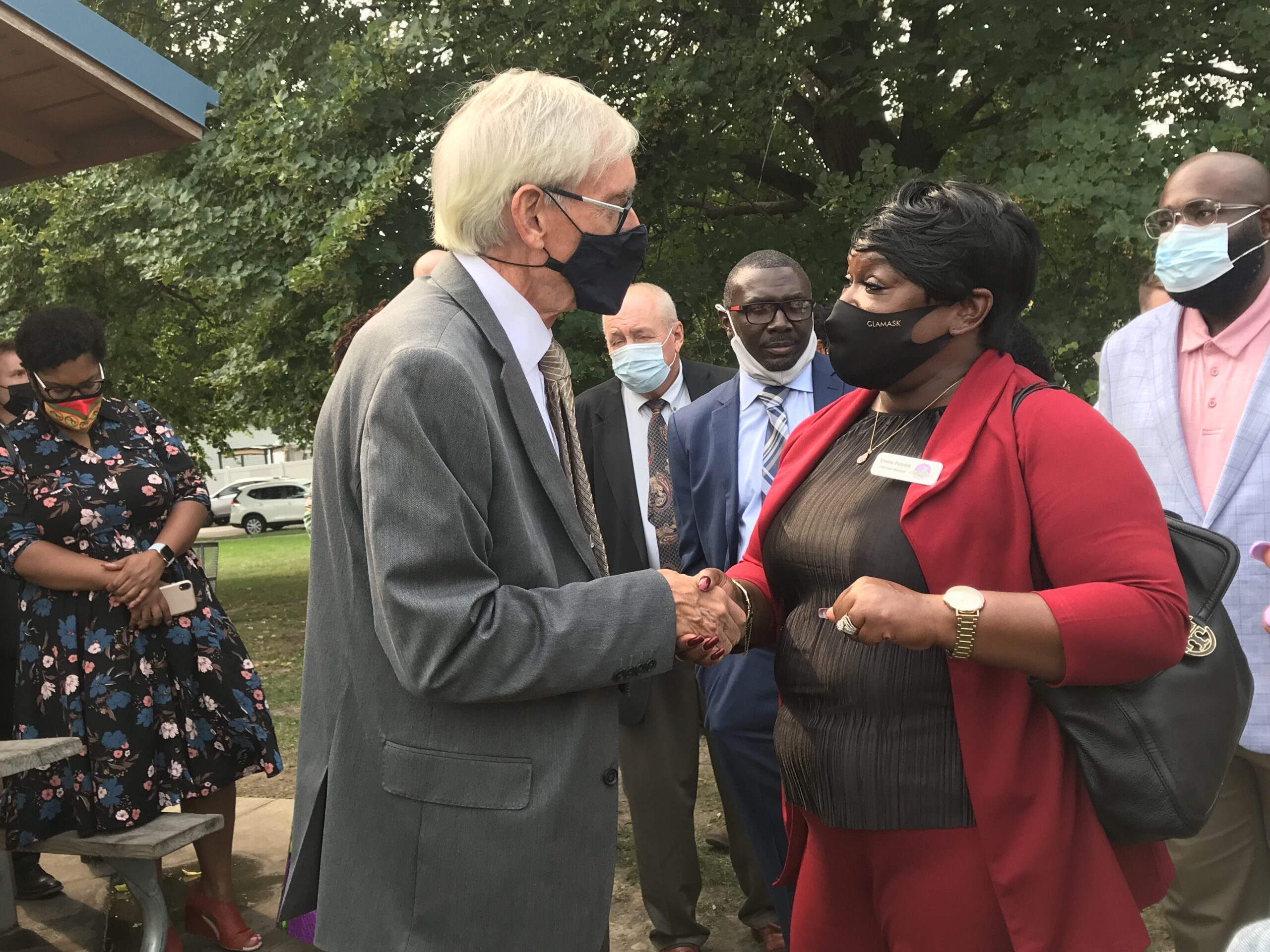 Governor Tony Evers, left, shakes the hand of Yvette Patrick, right, a Milwaukee woman who received a pardon.