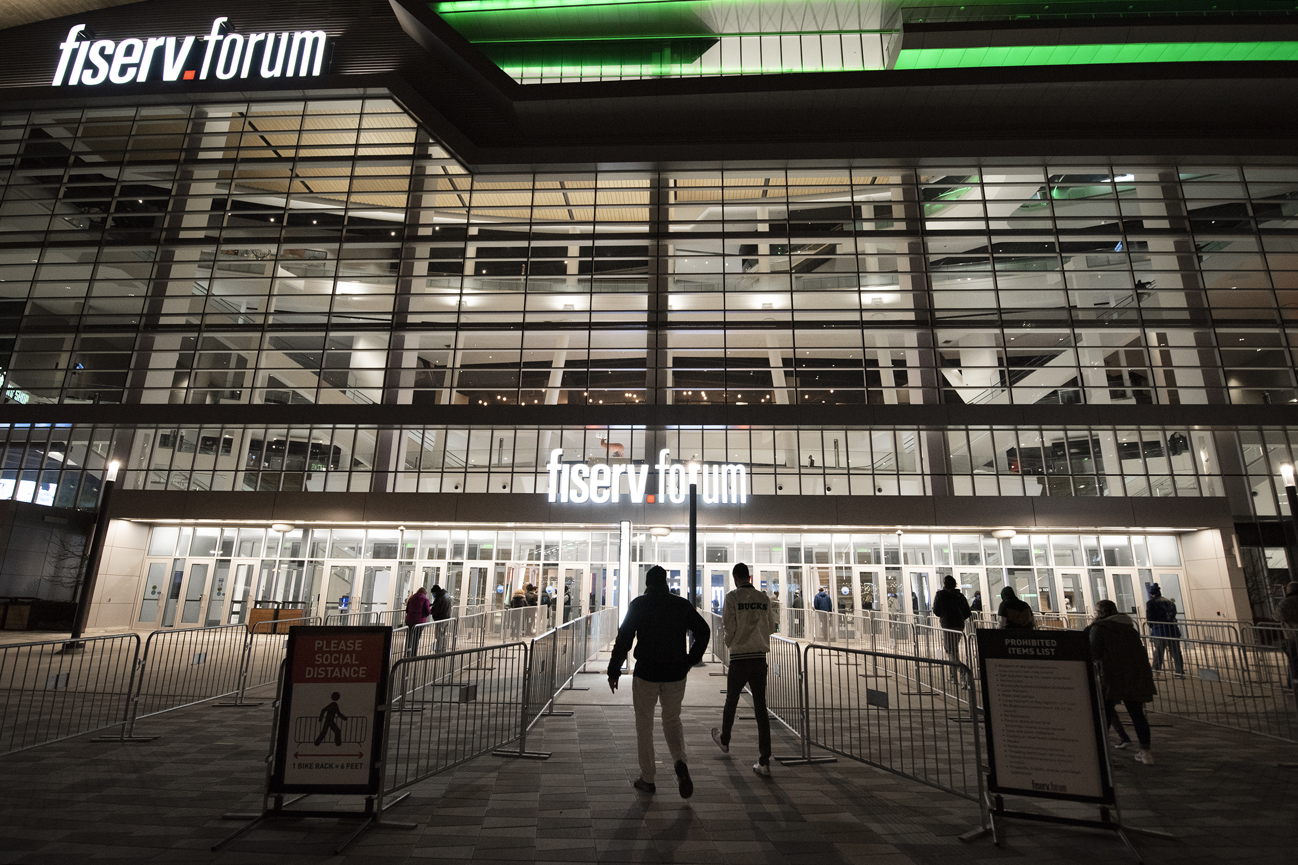 People enter the Fiserv Forum at night