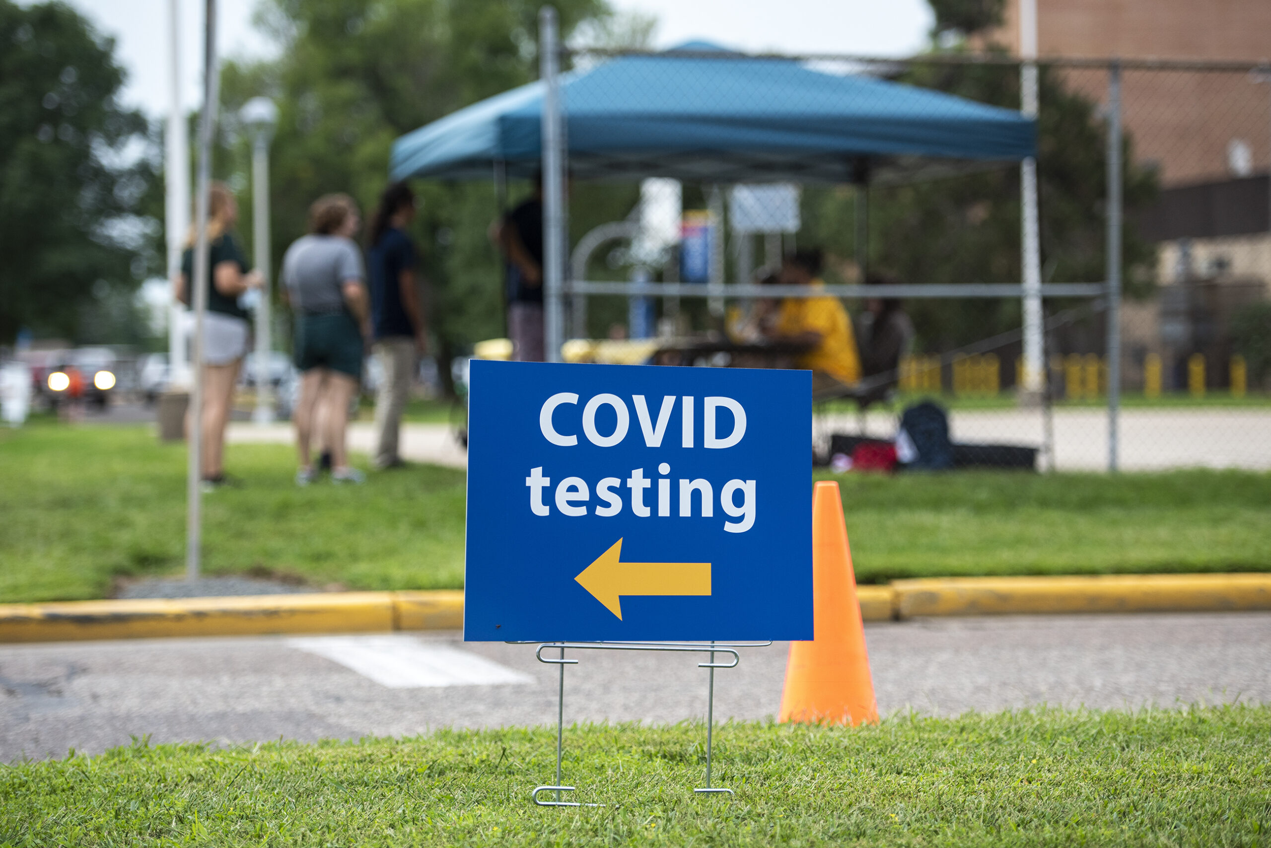 A blue sign says "COVID Testing" on it.
