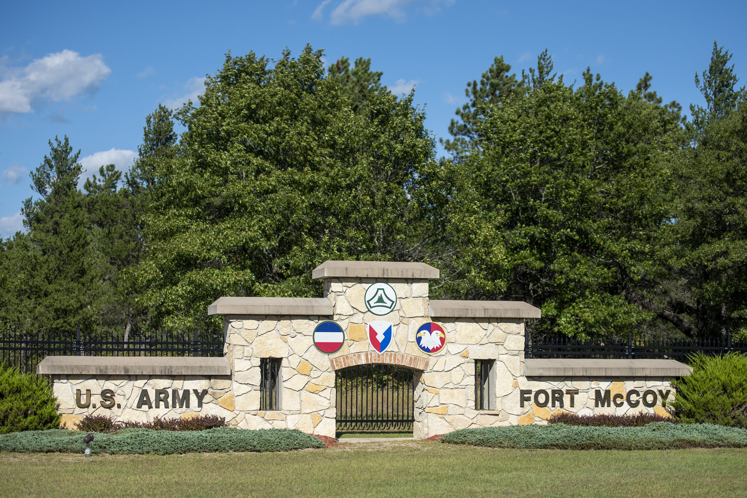 A decorative sign made with tan stone says "U.S. Army, Fort McCoy"