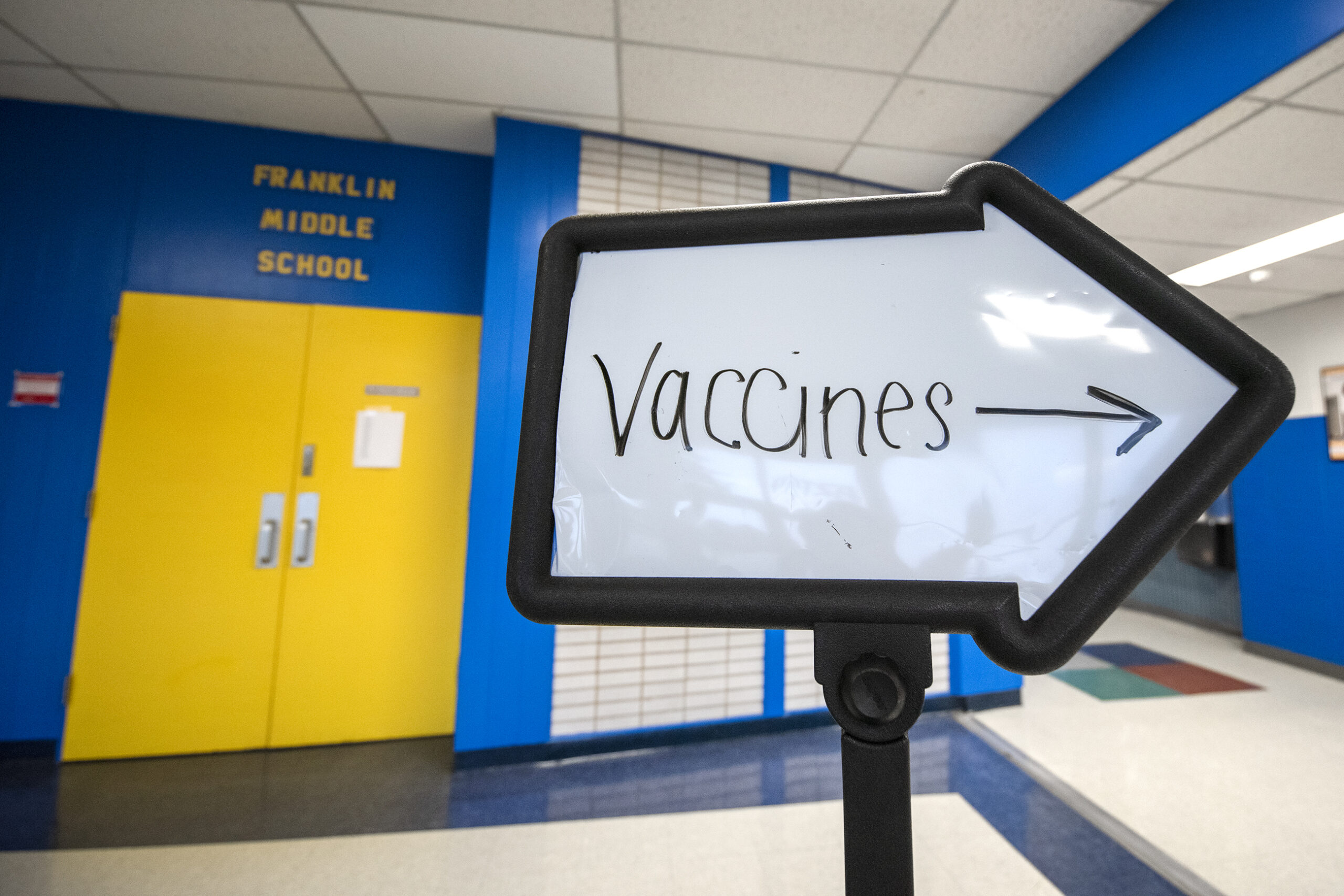 A sign in the shape of an arrow says "Vaccines."