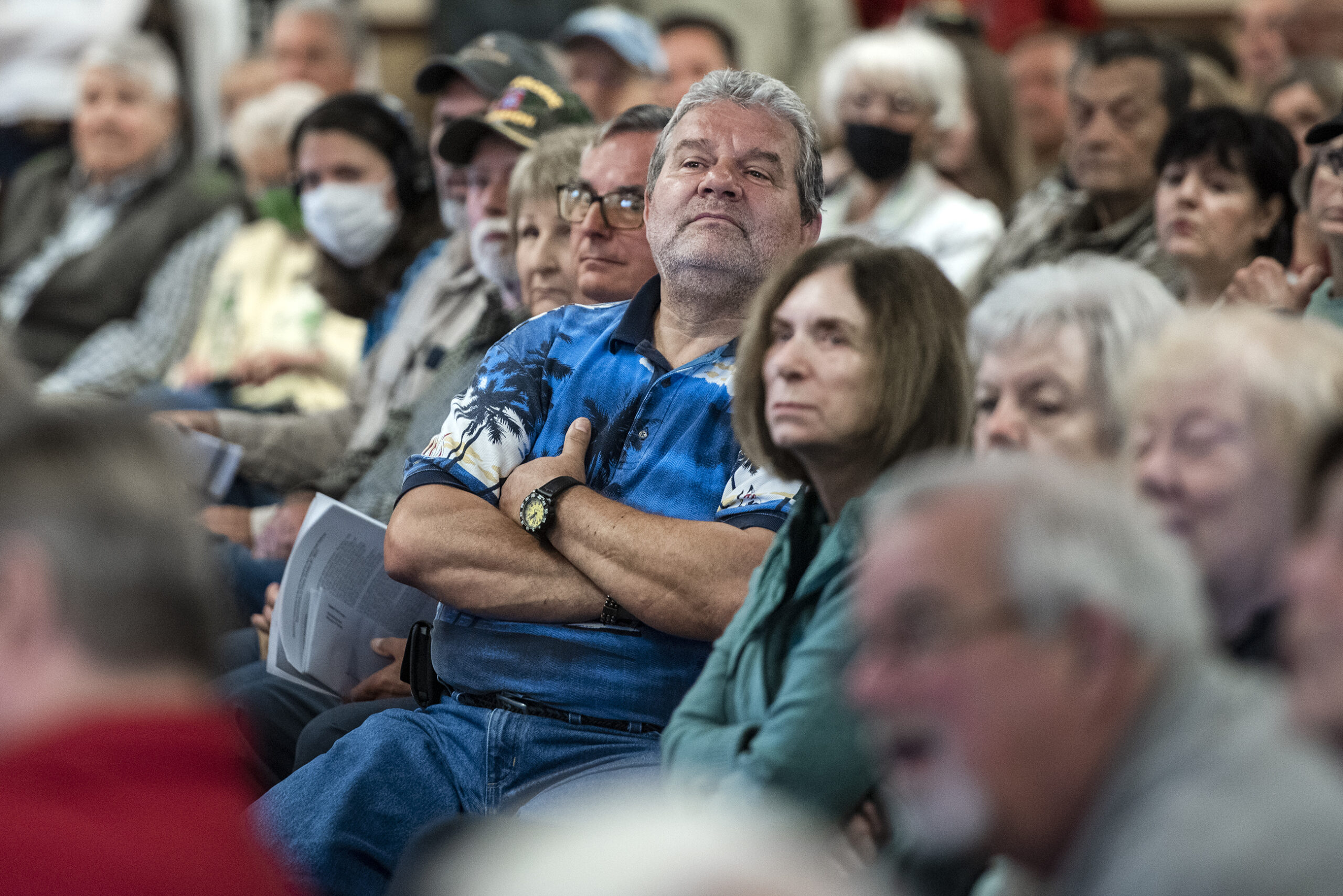 A constituent crosses his arms and lifts his head to see Sen. Ron Johnson.