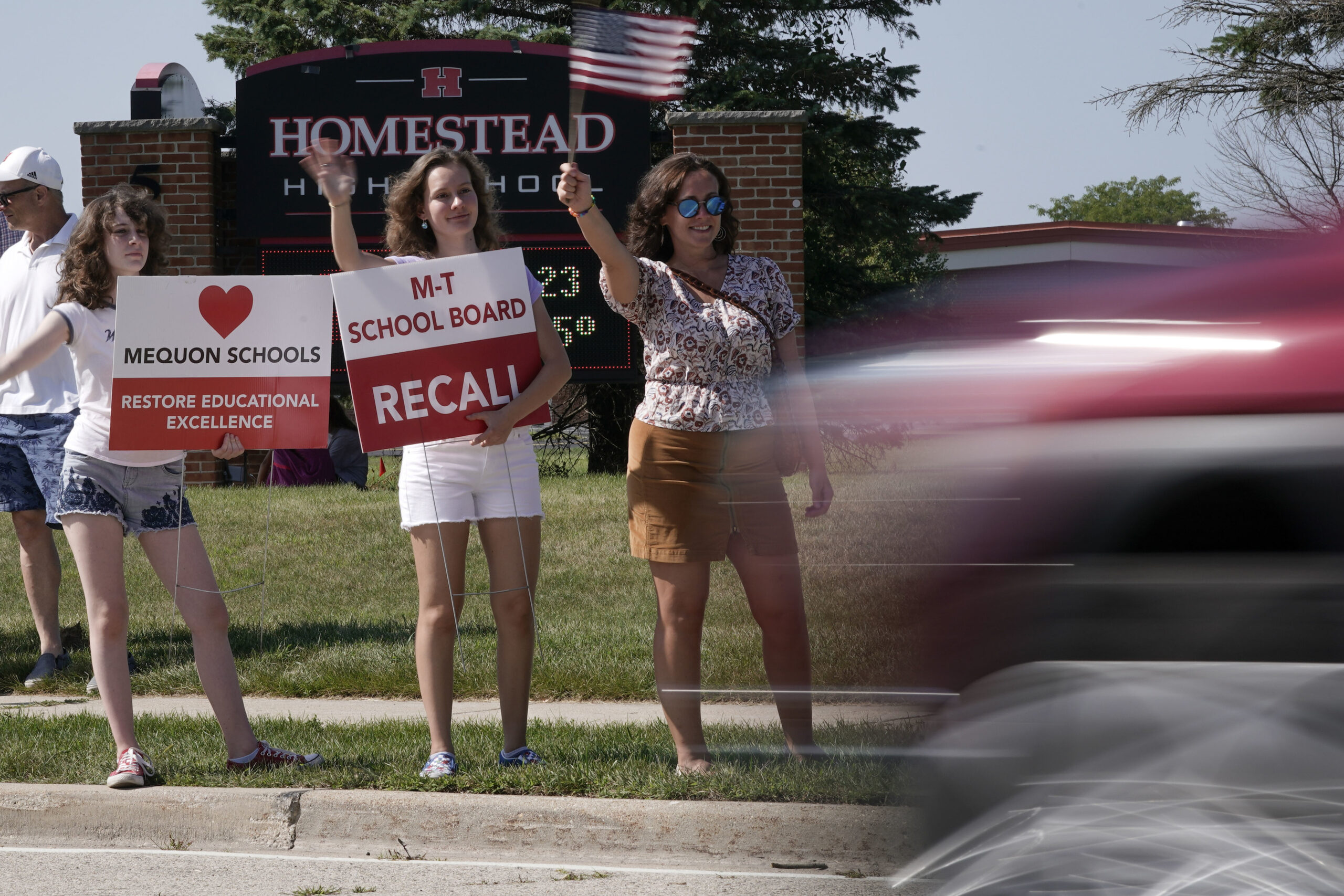 Supporters to recall the entire Mequon-Thiensville School District School Board wave at cars