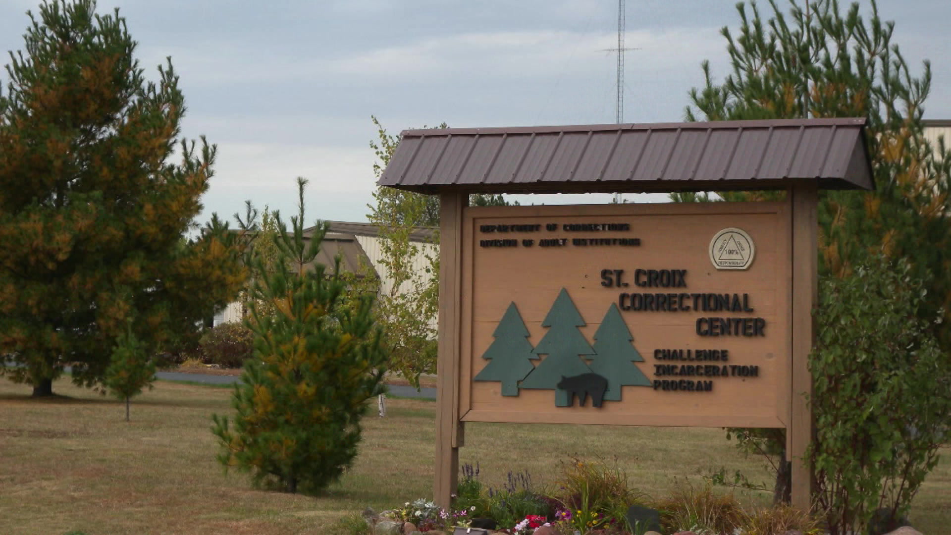 A sign for the St. Croix Correctional Center and its Challenge Incarceration Program is surrounded by pine trees.