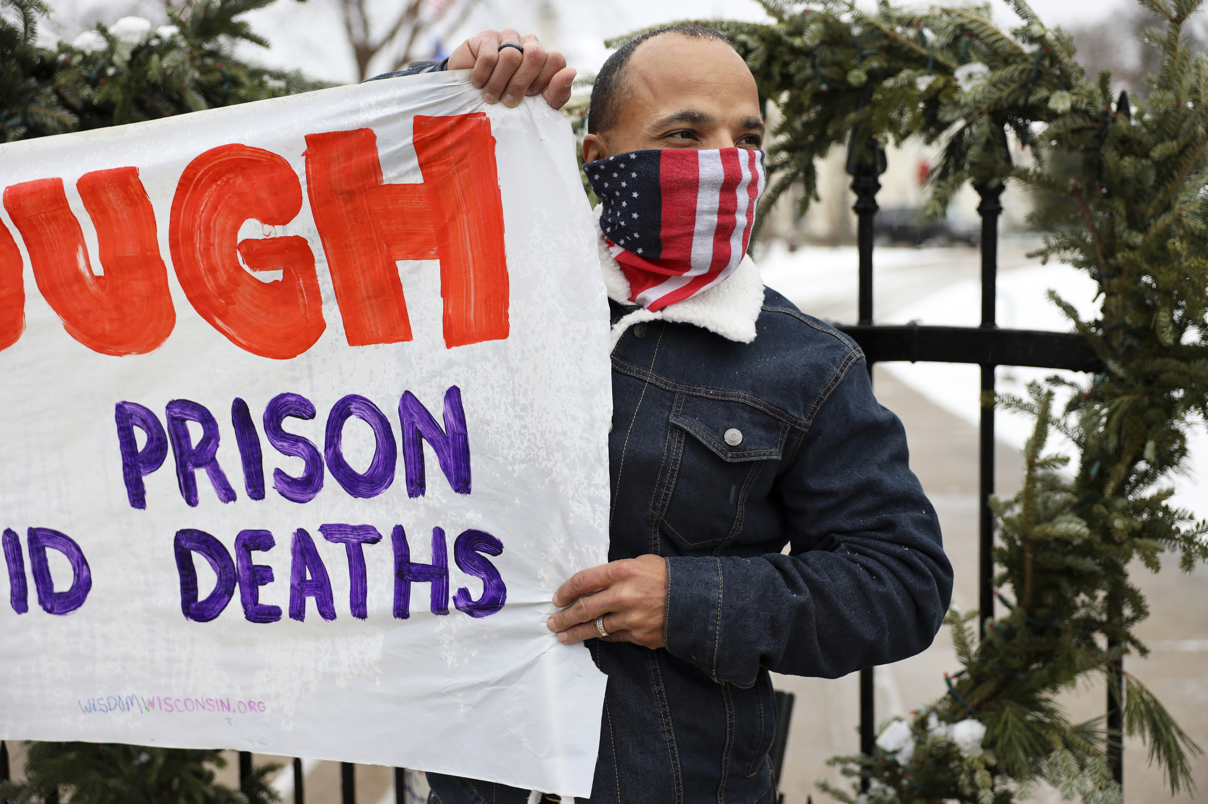 Ramiah Whiteside of Milwaukee holds a sign during a protest against the spread of COVID-19 in Wisconsin prisons