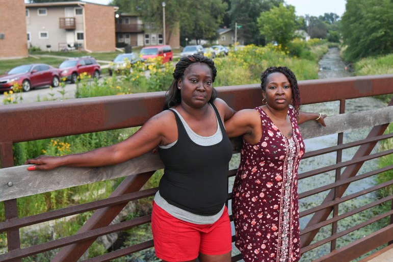 Melody Homesly and Carnetta Galvin stand on a bridge that crosses Starkweather Creek