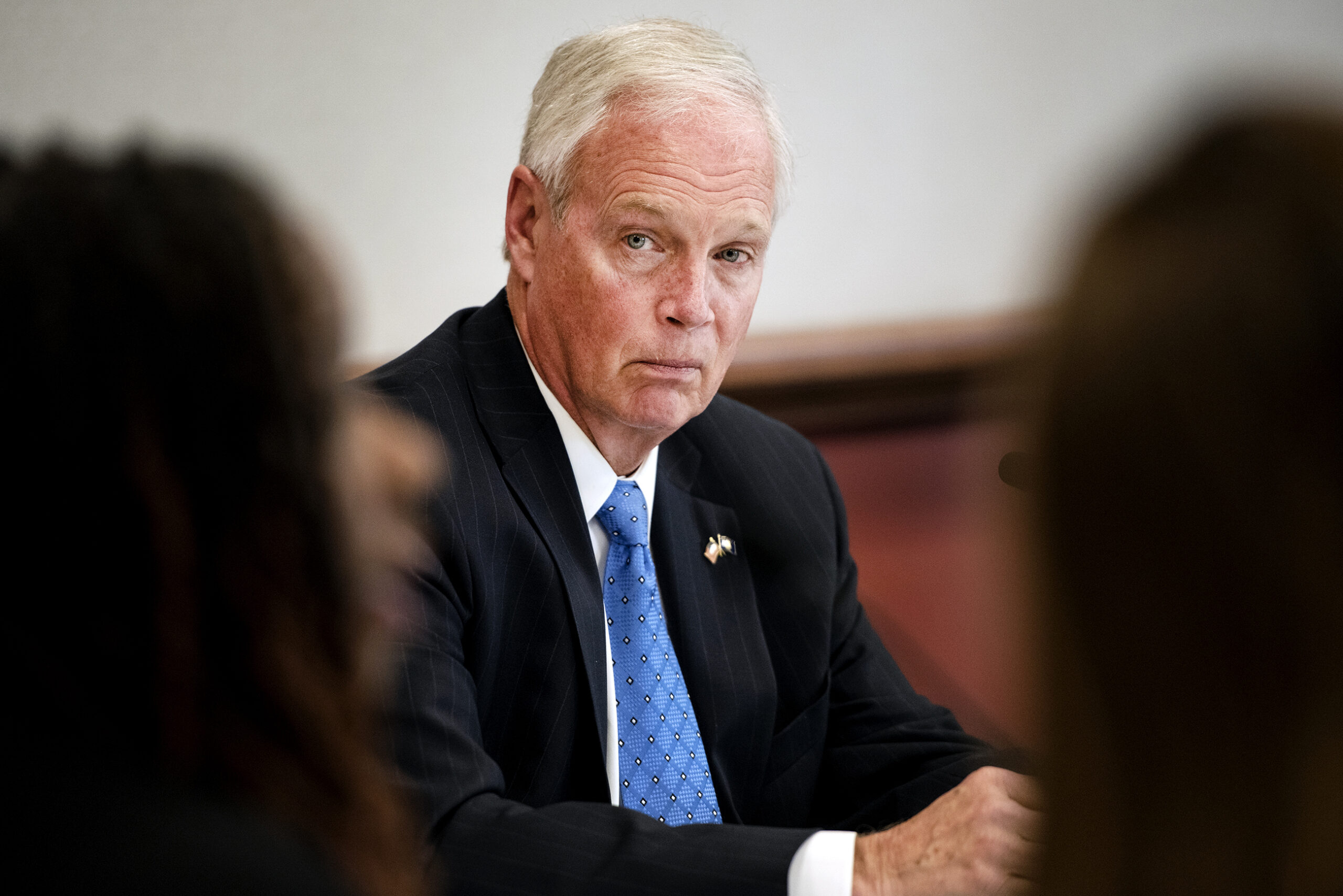 Sen. Ron Johnson watches guests as they speak during a press conference.