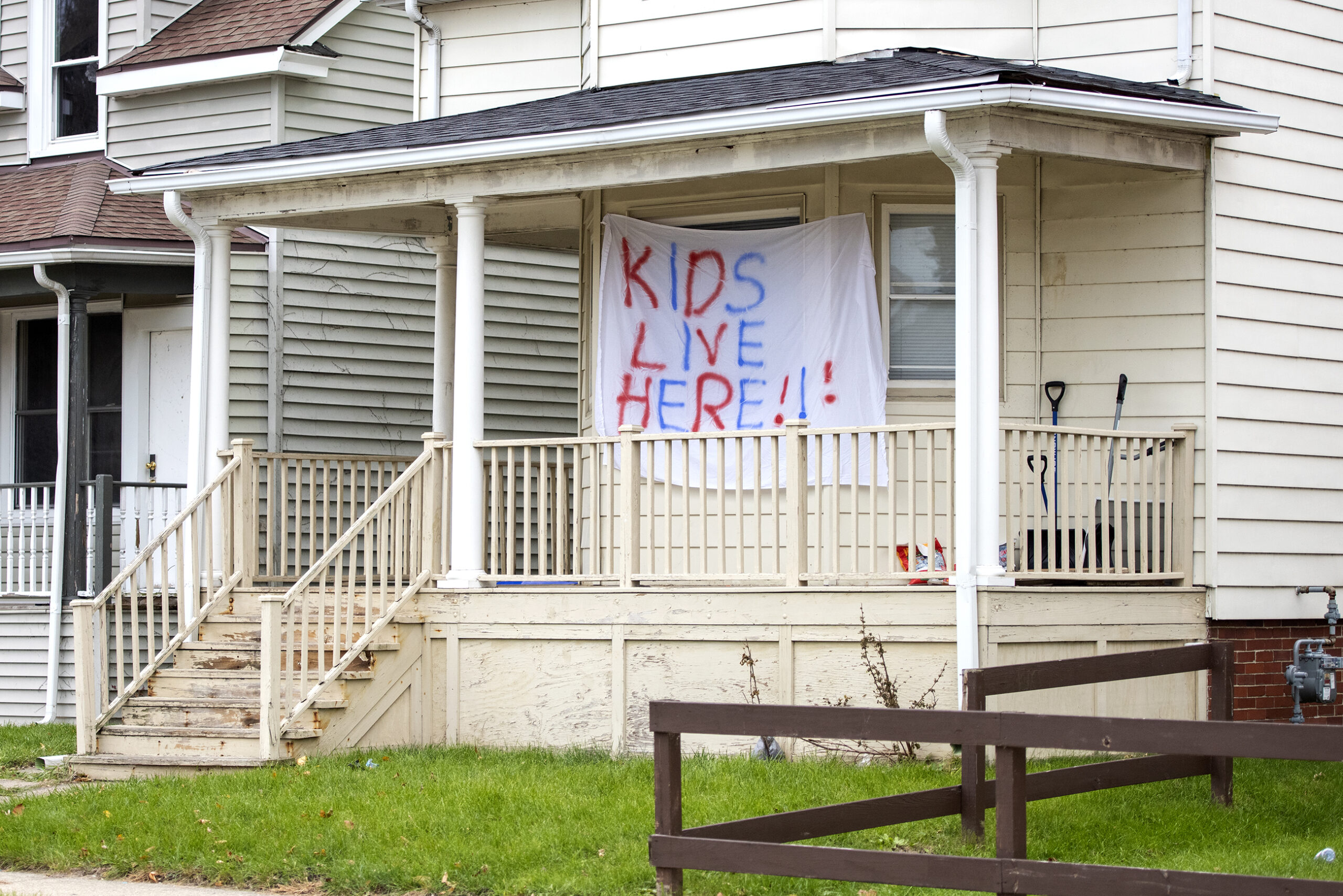 A large sheet hung outside the front of a house says 