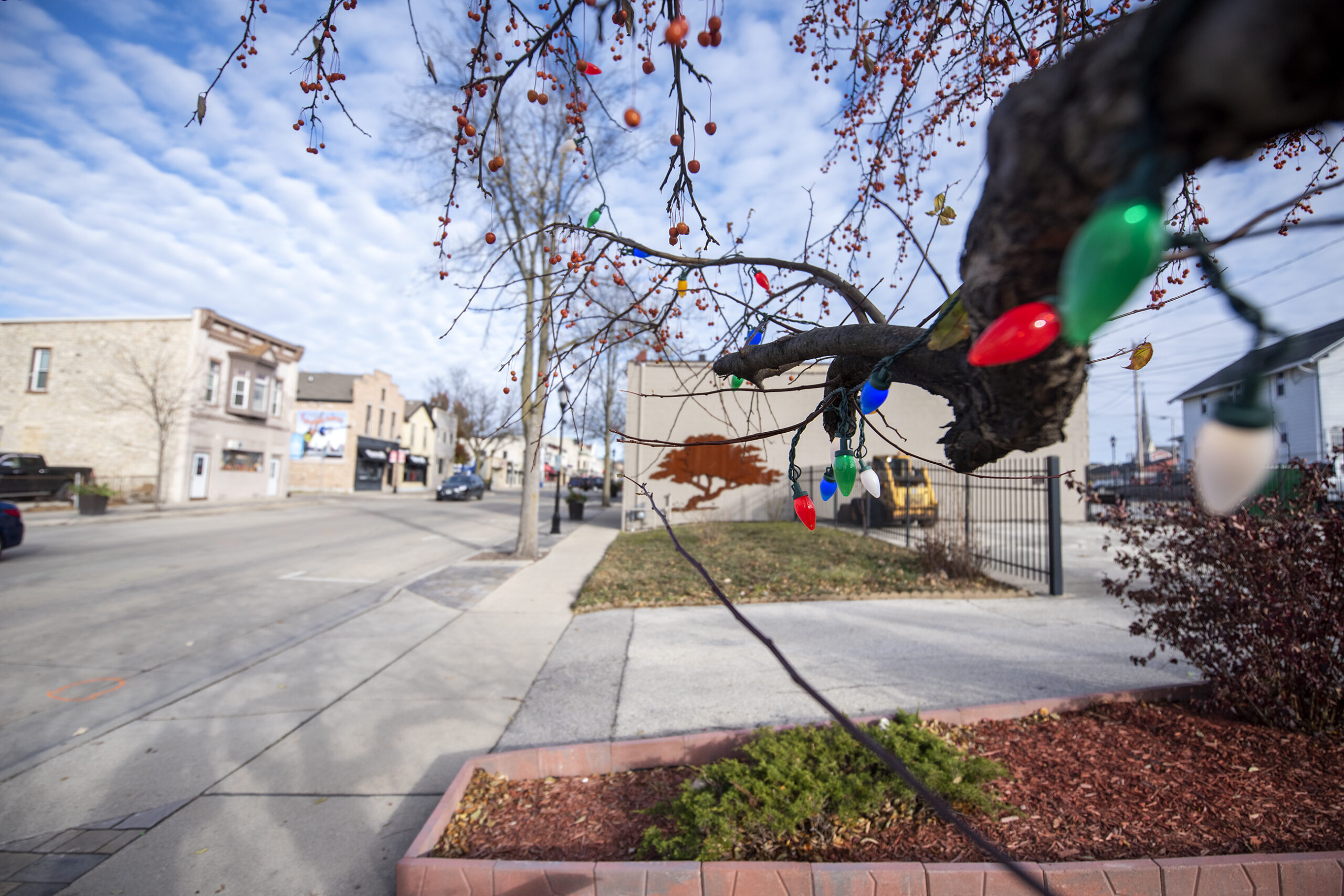 Colorful Christmas lights can be seen on Main Street in Waukesha under a blue sky.