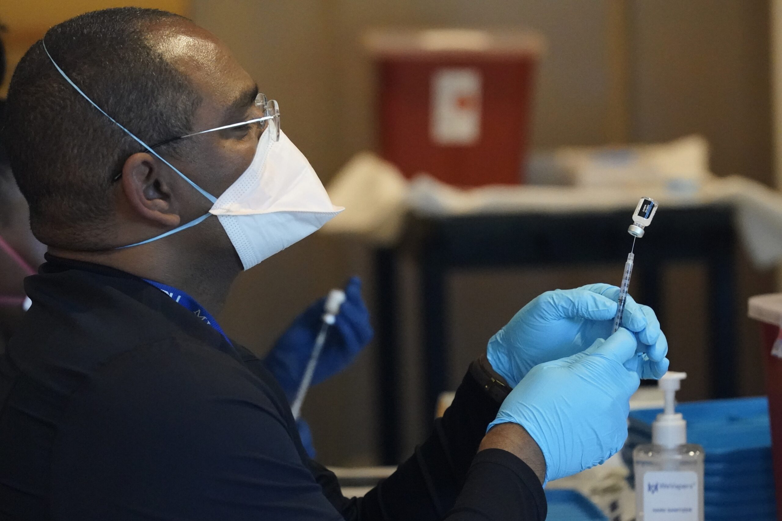 A health care worker fills a syringe with the COVID-19 vaccine