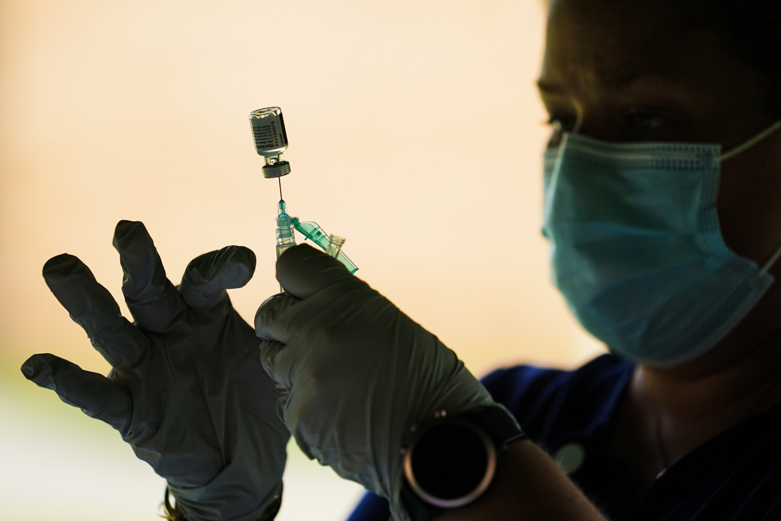 A syringe is prepared with the Pfizer COVID-19 vaccine at a clinic