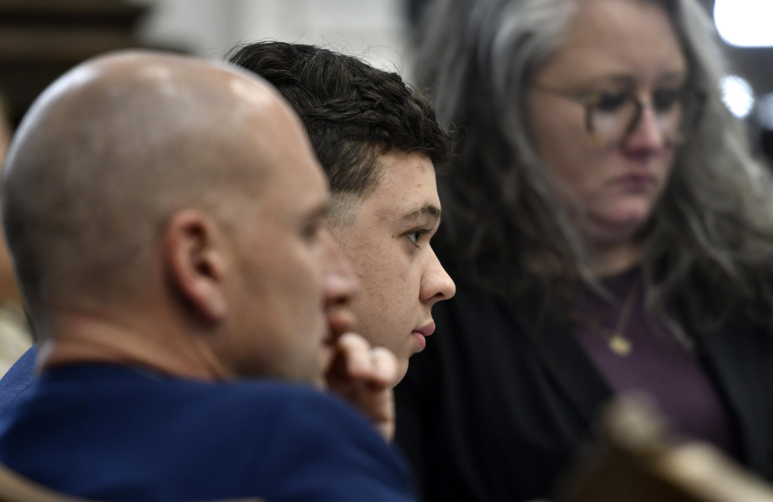 Kyle Rittenhouse, center, watches a video from "The Rundown Live" during his trial