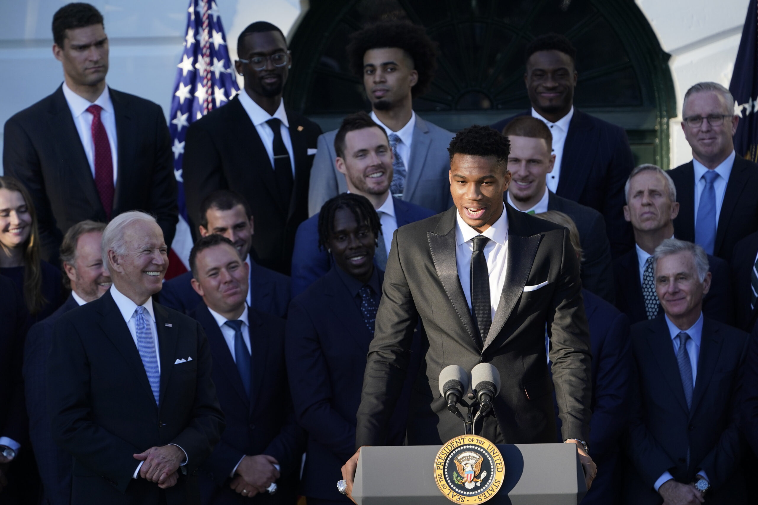 President Joe Biden listens as Giannis Antetokounmpo speaks during an event to welcome the Milwaukee Bucks basketball team to the White House