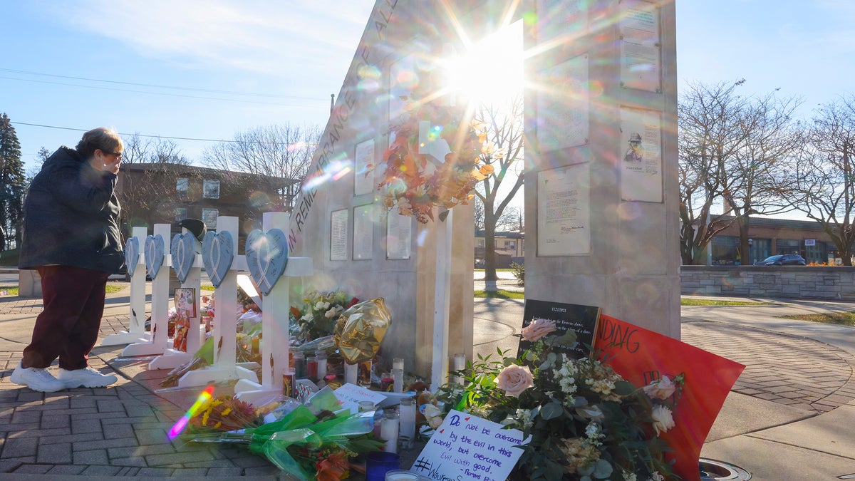 A person cries at a memorial in Waukesha, Wis.