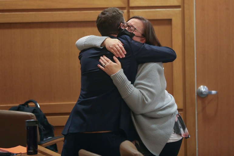 Two people hug in relief after a judge's verdict