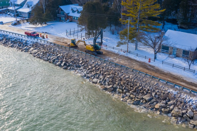 Town of Baileys Harbor, Wis., maintenance crews and contractors work to restore residential access with giant limestone boulders after the road collapsed into Lake Michigan due to high water levels