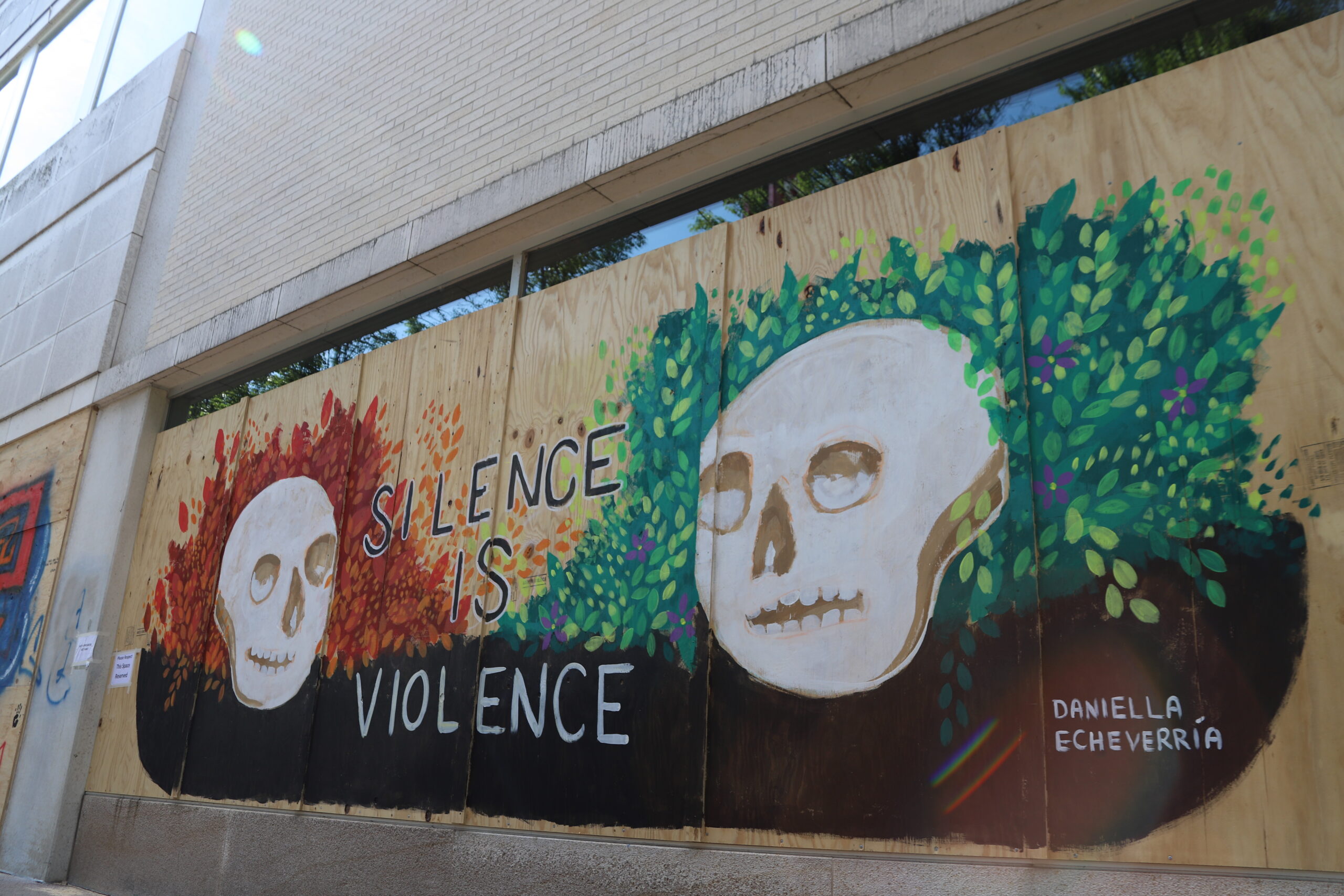 A protest mural that reads "Silence is violence"