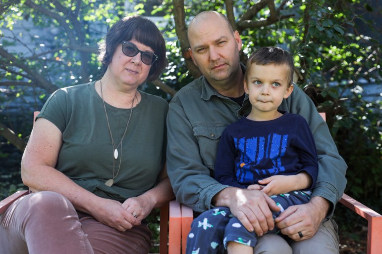 A mother and father pose with their 4-year-old son