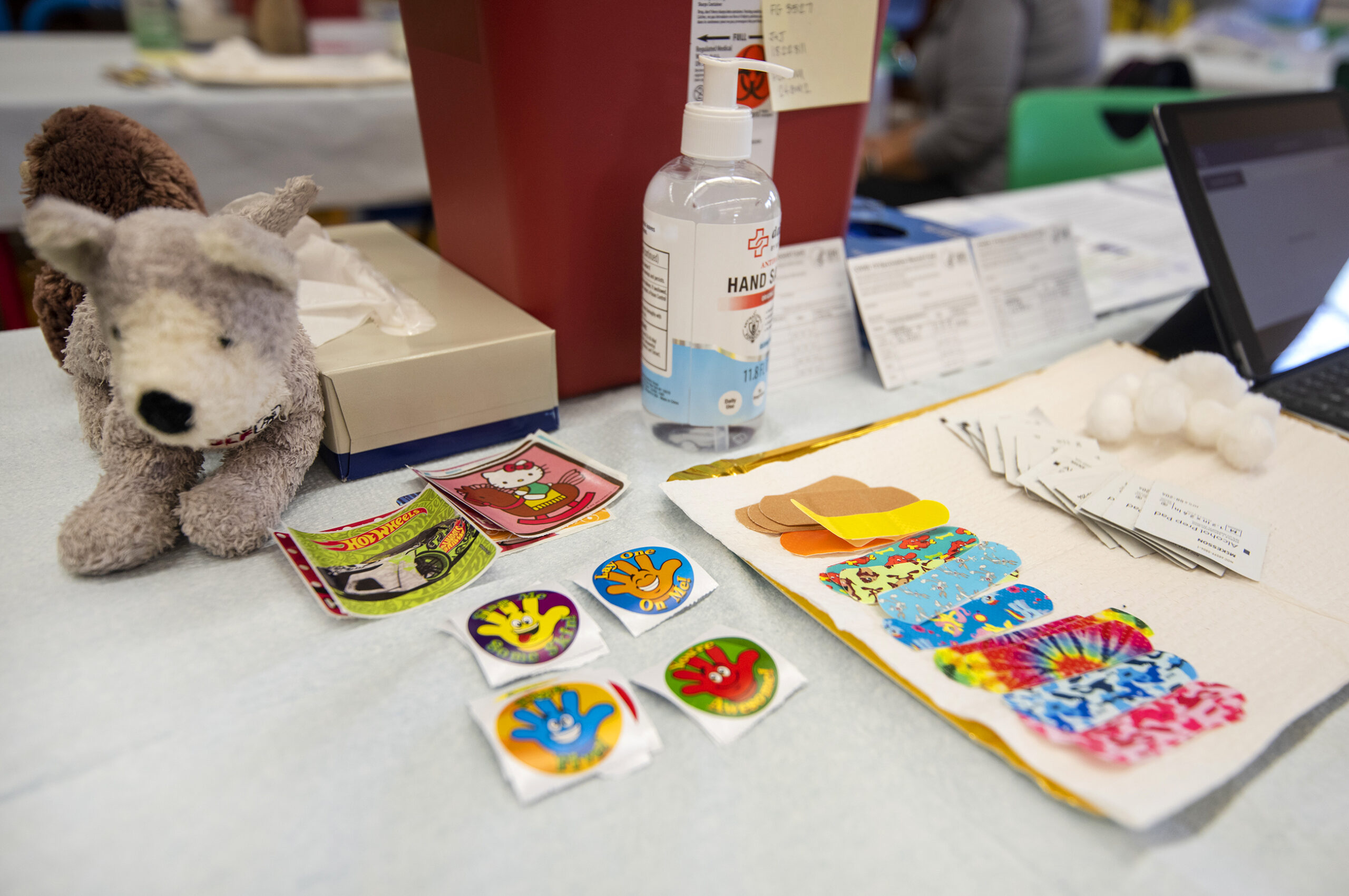 Stickers and bandages with colorful patterns sit on top of a white table cloth.