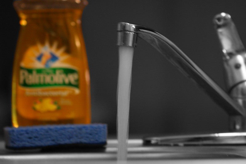 Kitchen sink with running water and dish soap