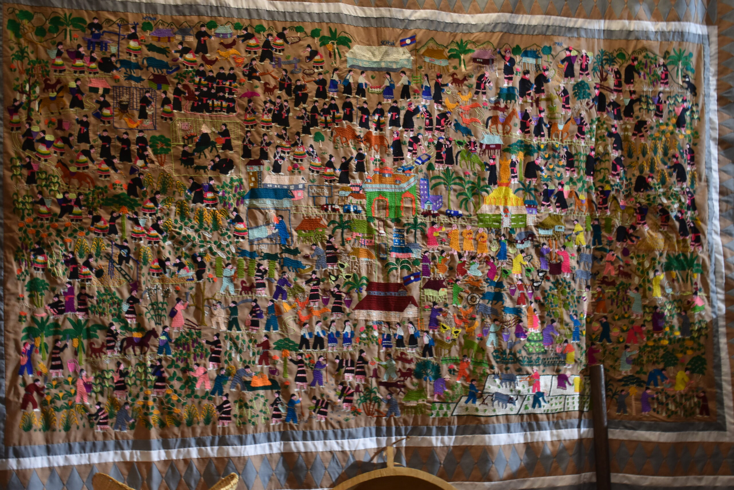 A Hmong story cloth hangs in the 