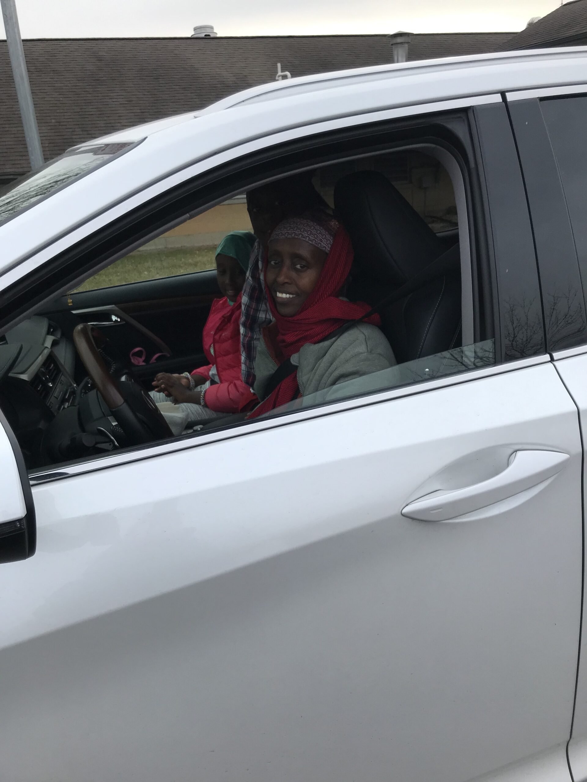 A woman sits in her car in line to get tested for COVID-19