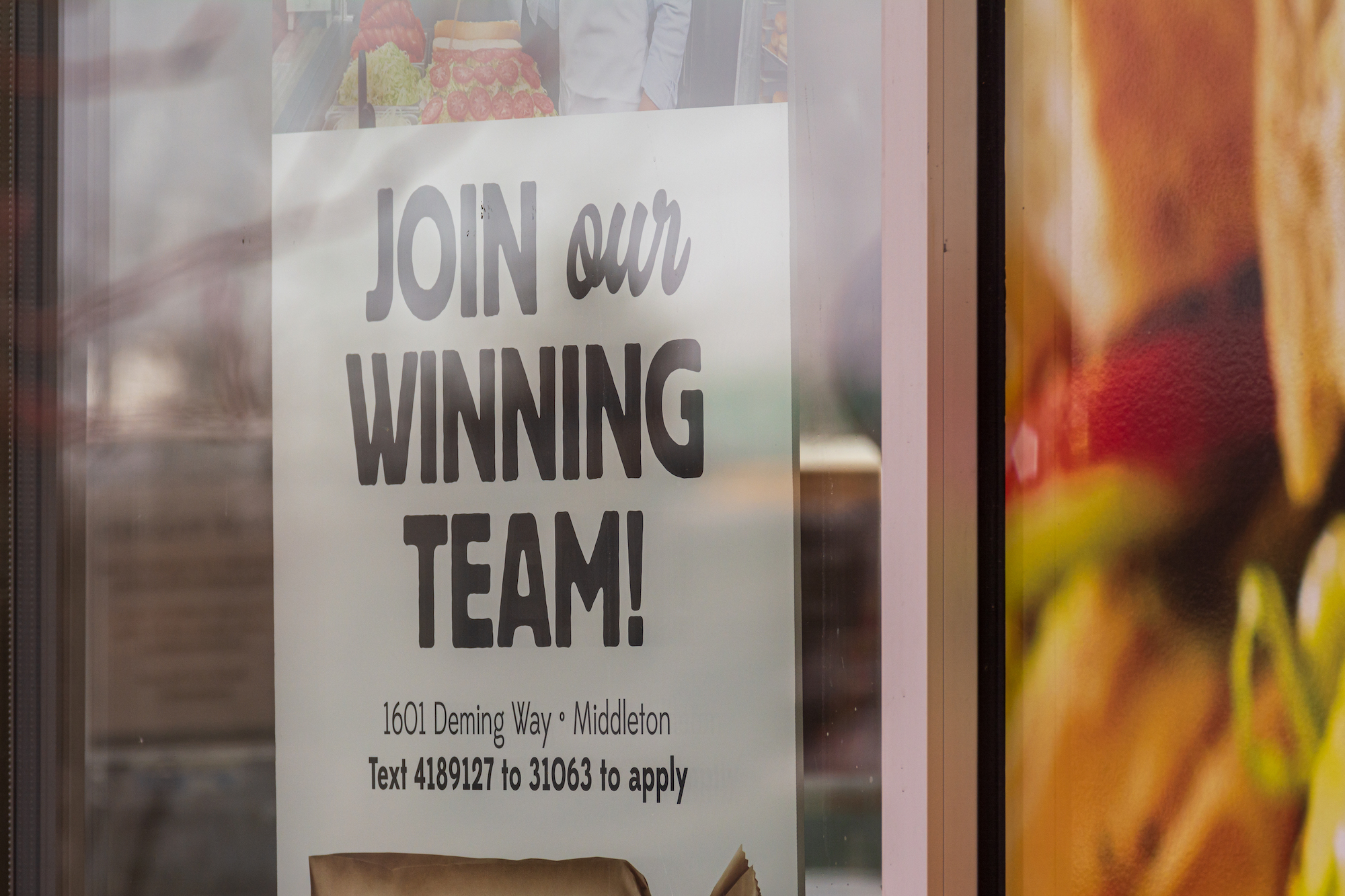 A sign in the window of a Middleton, Wis. restaurant saying it's looking for workers to hire on Jan. 4, 2022.