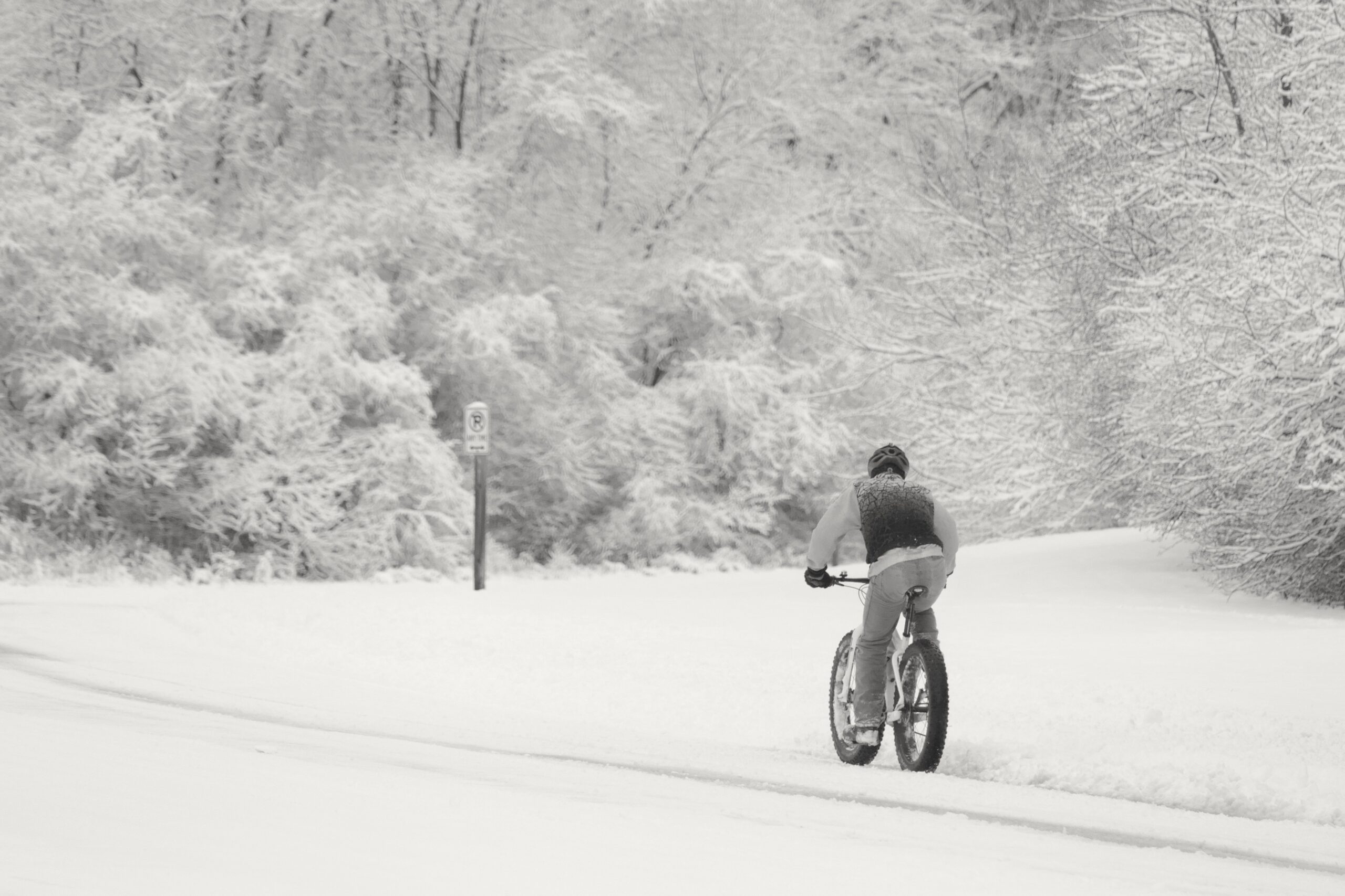 A bicyclist riding through the snow