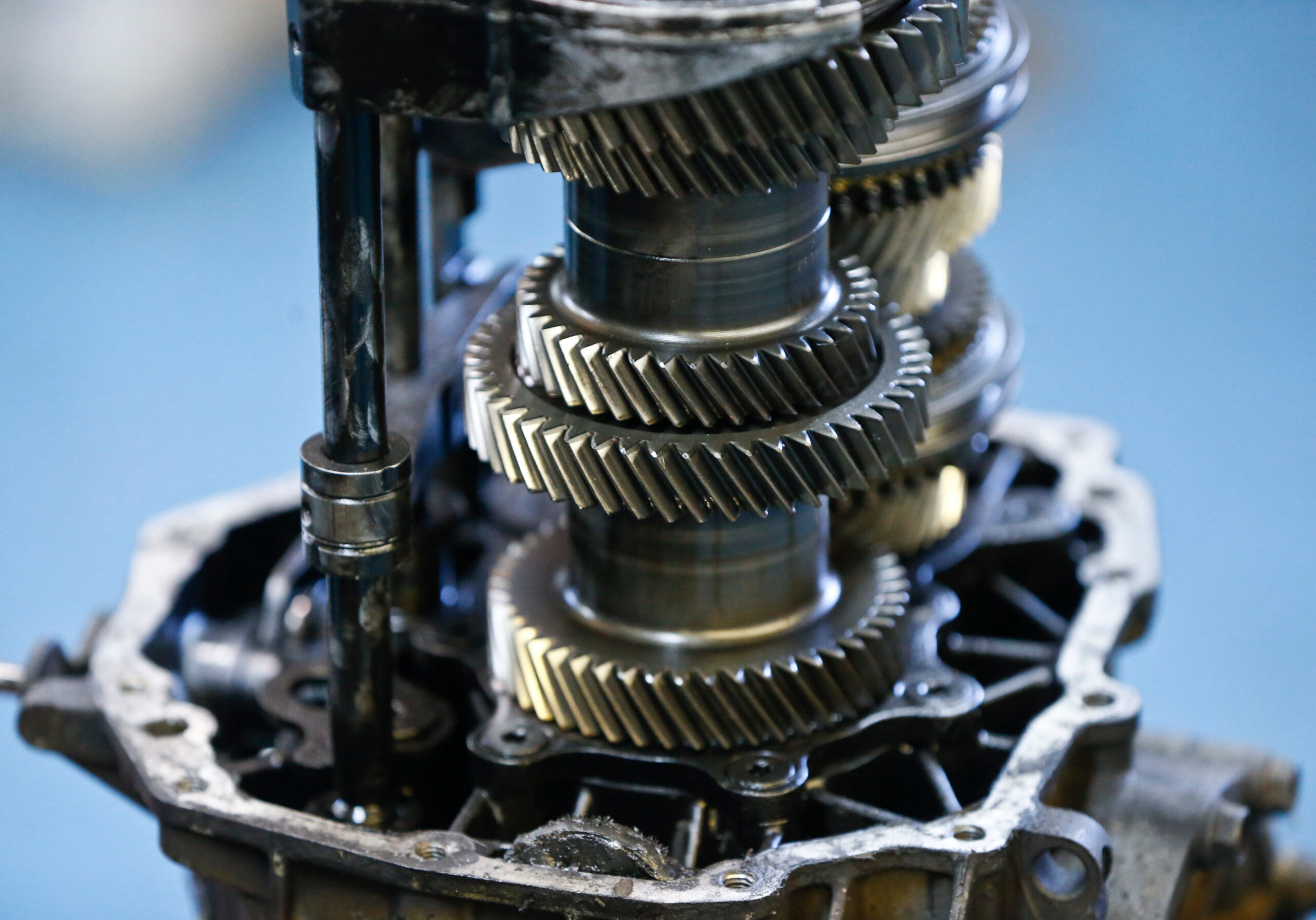 The exposed gears of a manual transmission are seen at a repair shop