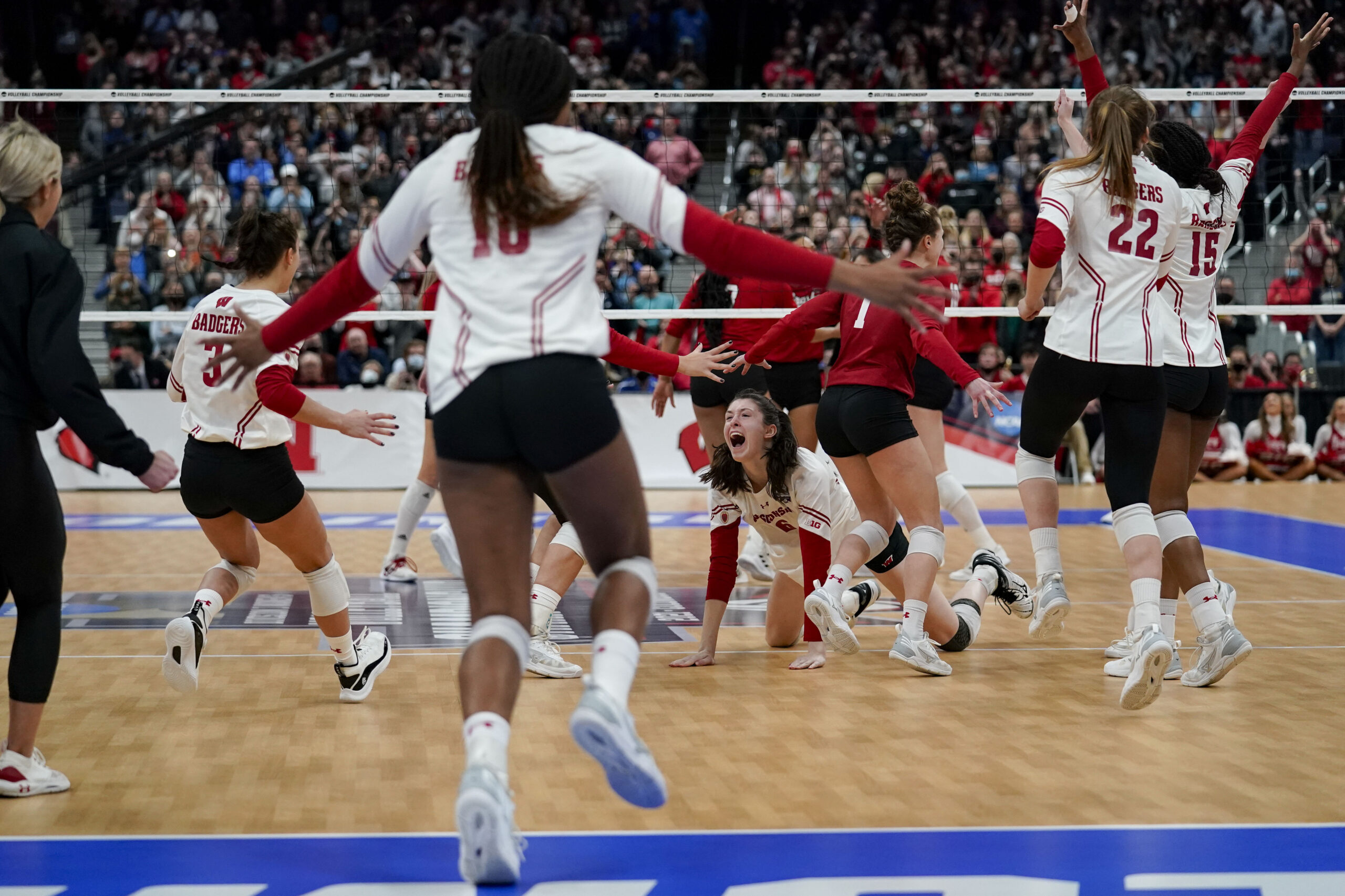 Wisconsin women's volleyball players celebrate after winning the NCAA title.