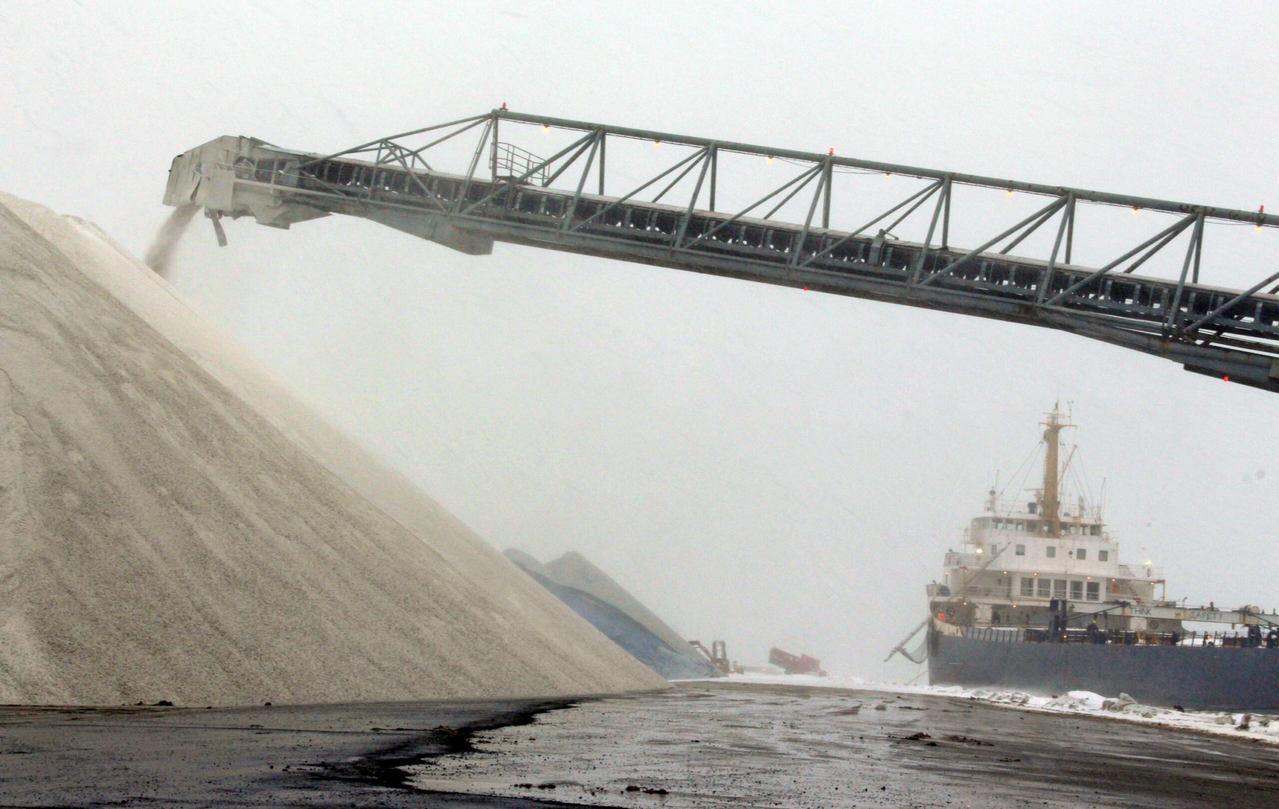 The Algosteel, right, unloads it's cargo of road salt at the Port of Milwaukee