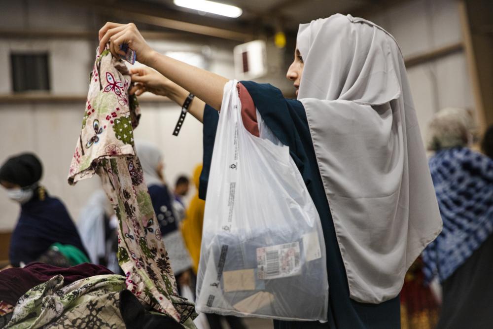 An Afghan Evacuee Sorts Through Clothing Donations